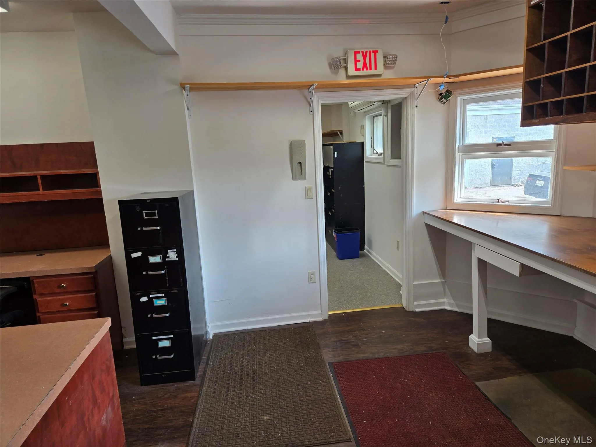 Unfurnished office featuring baseboards and dark wood-style flooring Unfurnished office featuring baseboards and dark wood-style flooring