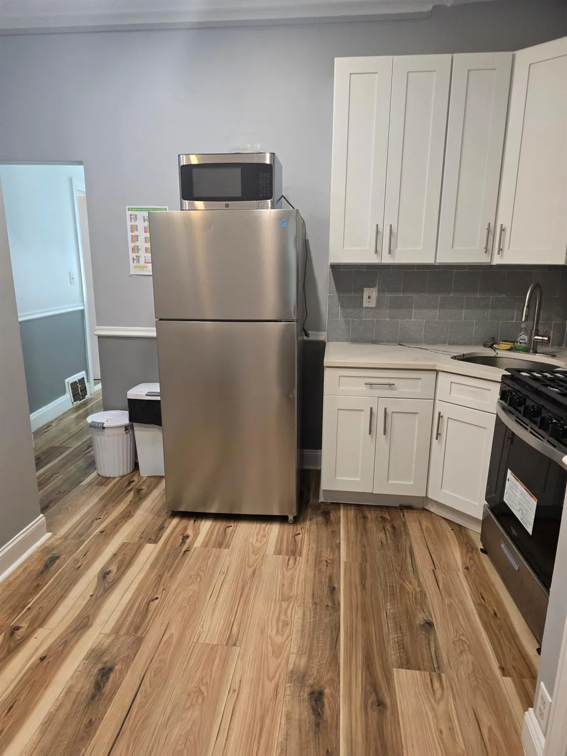 Kitchen featuring appliances with stainless steel finishes, light countertops, a sink, and light wood finished floors Kitchen featuring appliances with stainless steel finishes, light countertops, a sink, and light wood finished floors