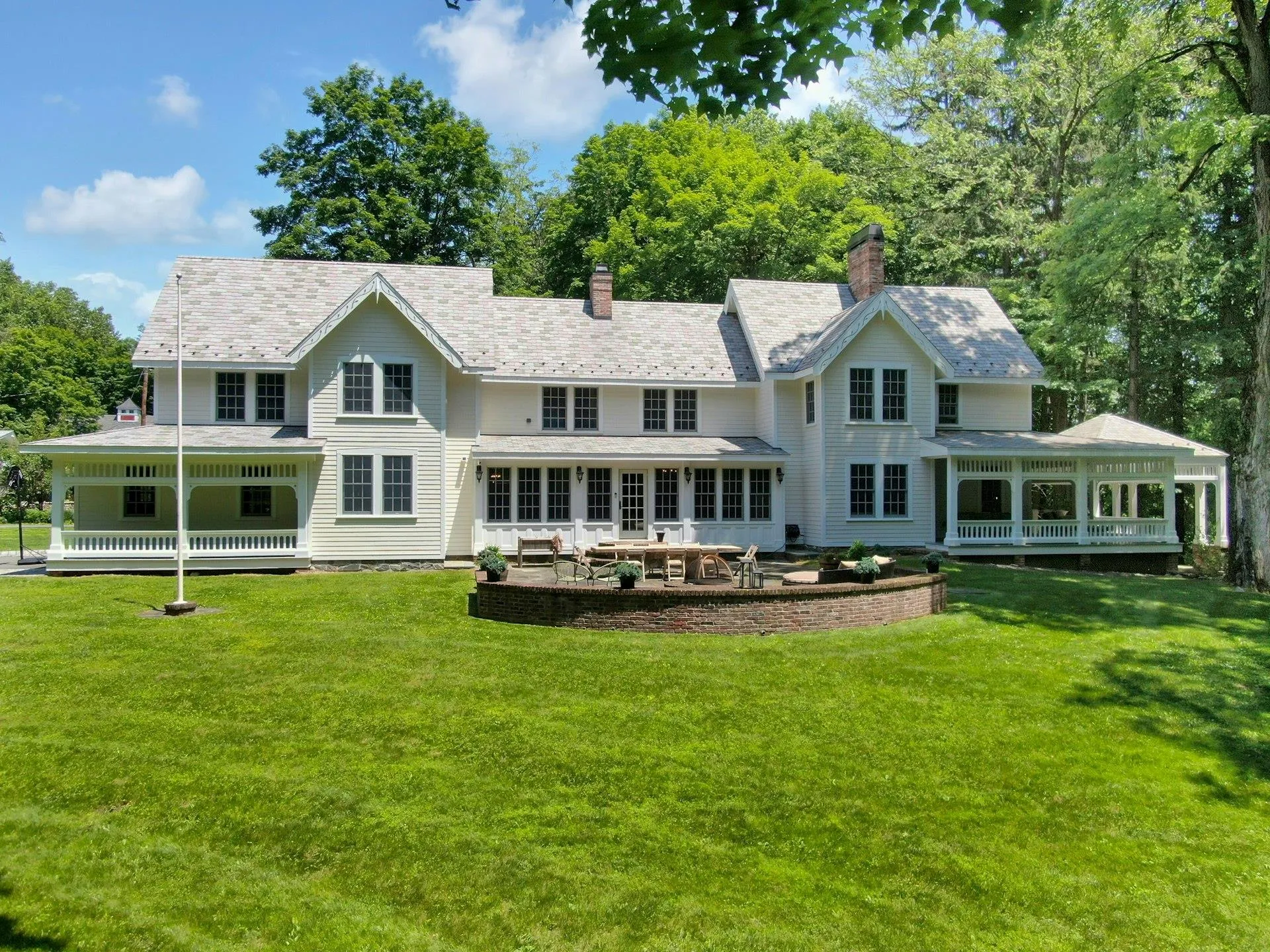 Back of property with a sunroom, a yard, and a chimney Back of property with a sunroom, a yard, and a chimney