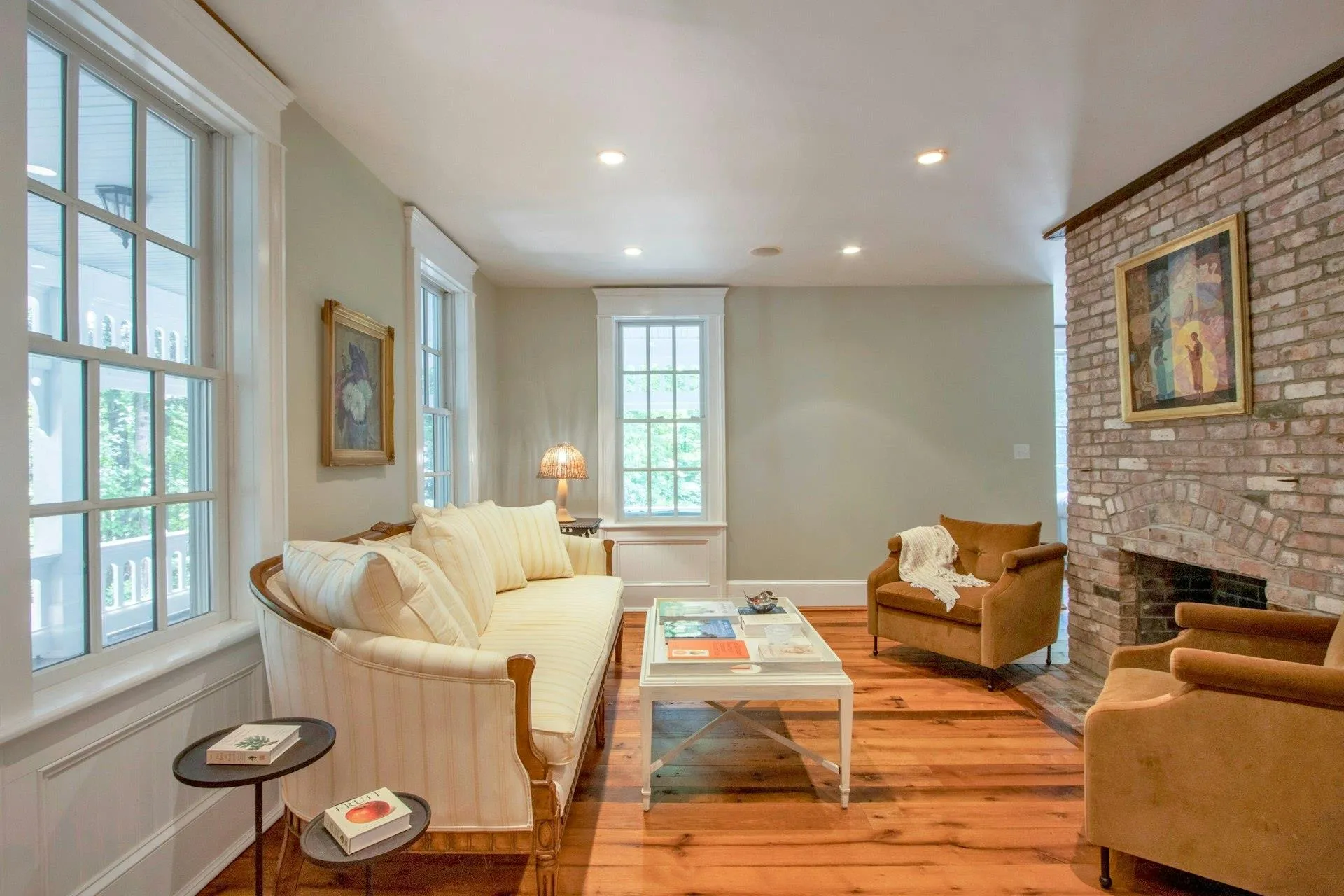 Living area with hardwood / wood-style flooring, a brick fireplace, and recessed lighting Living area with hardwood / wood-style flooring, a brick fireplace, and recessed lighting