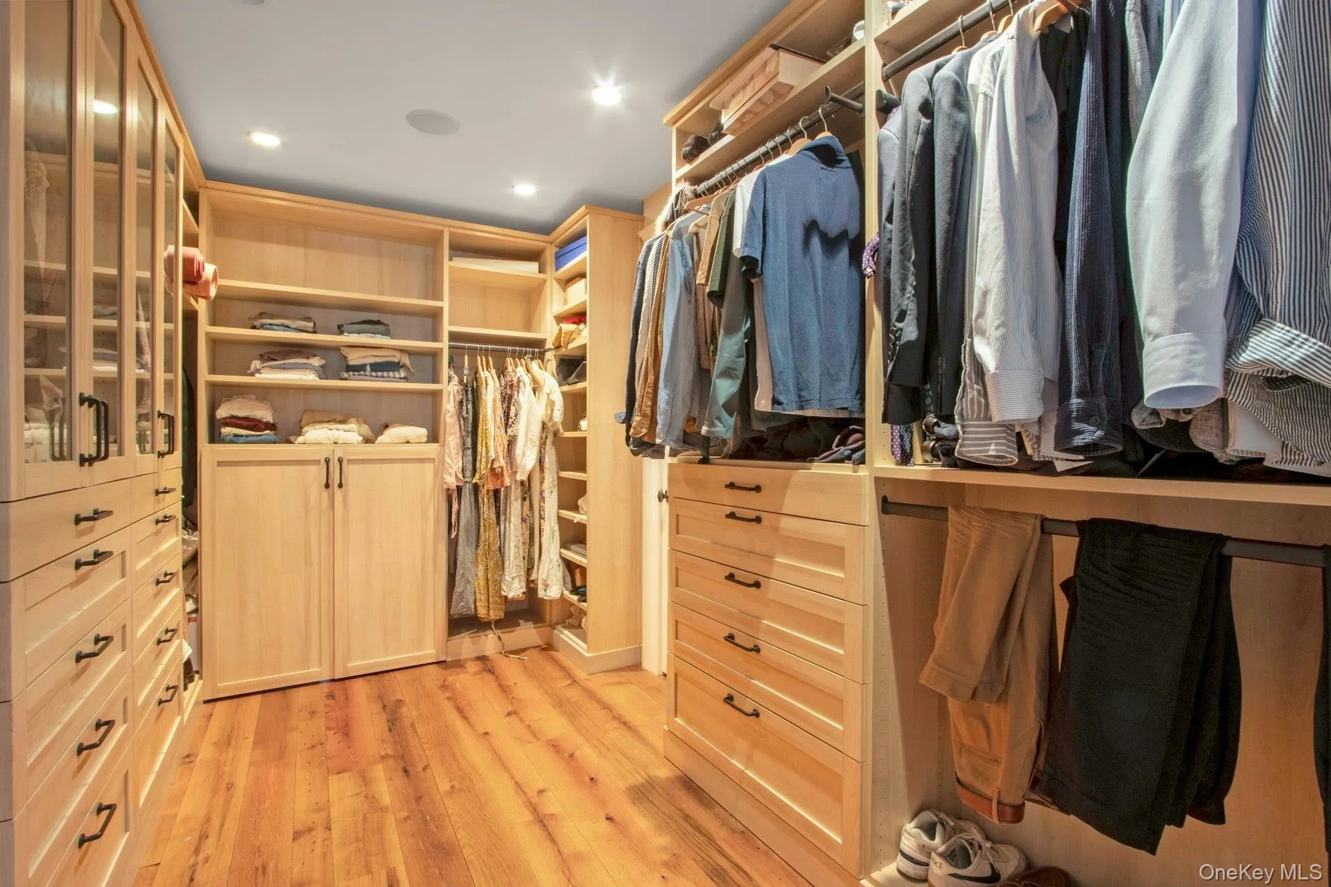 Walk in closet with light wood-style flooring Walk in closet with light wood-style flooring