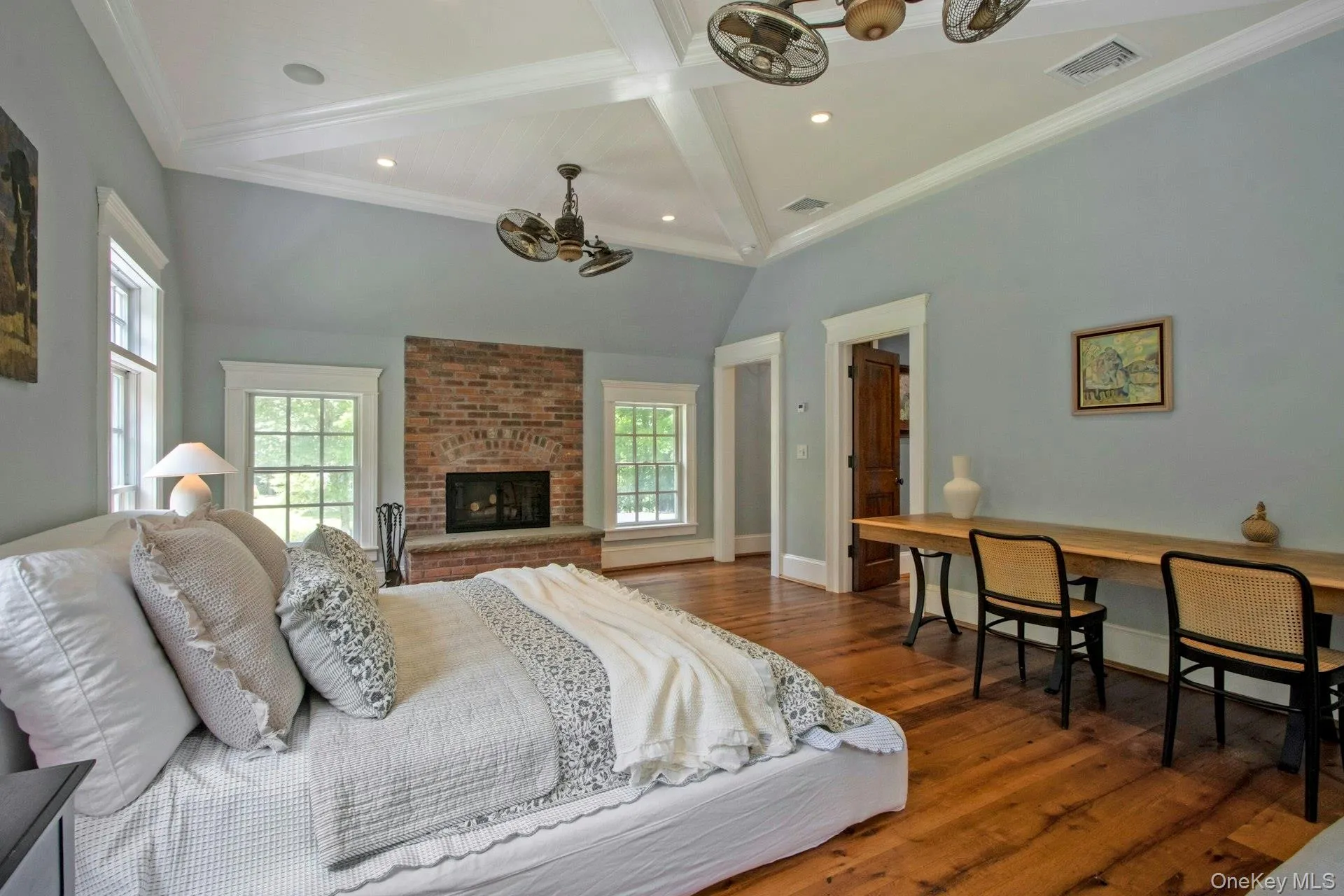 Bedroom featuring a chandelier, multiple windows, wood finished floors, a fireplace, and recessed lighting Bedroom featuring a chandelier, multiple windows, wood finished floors, a fireplace, and recessed lighting