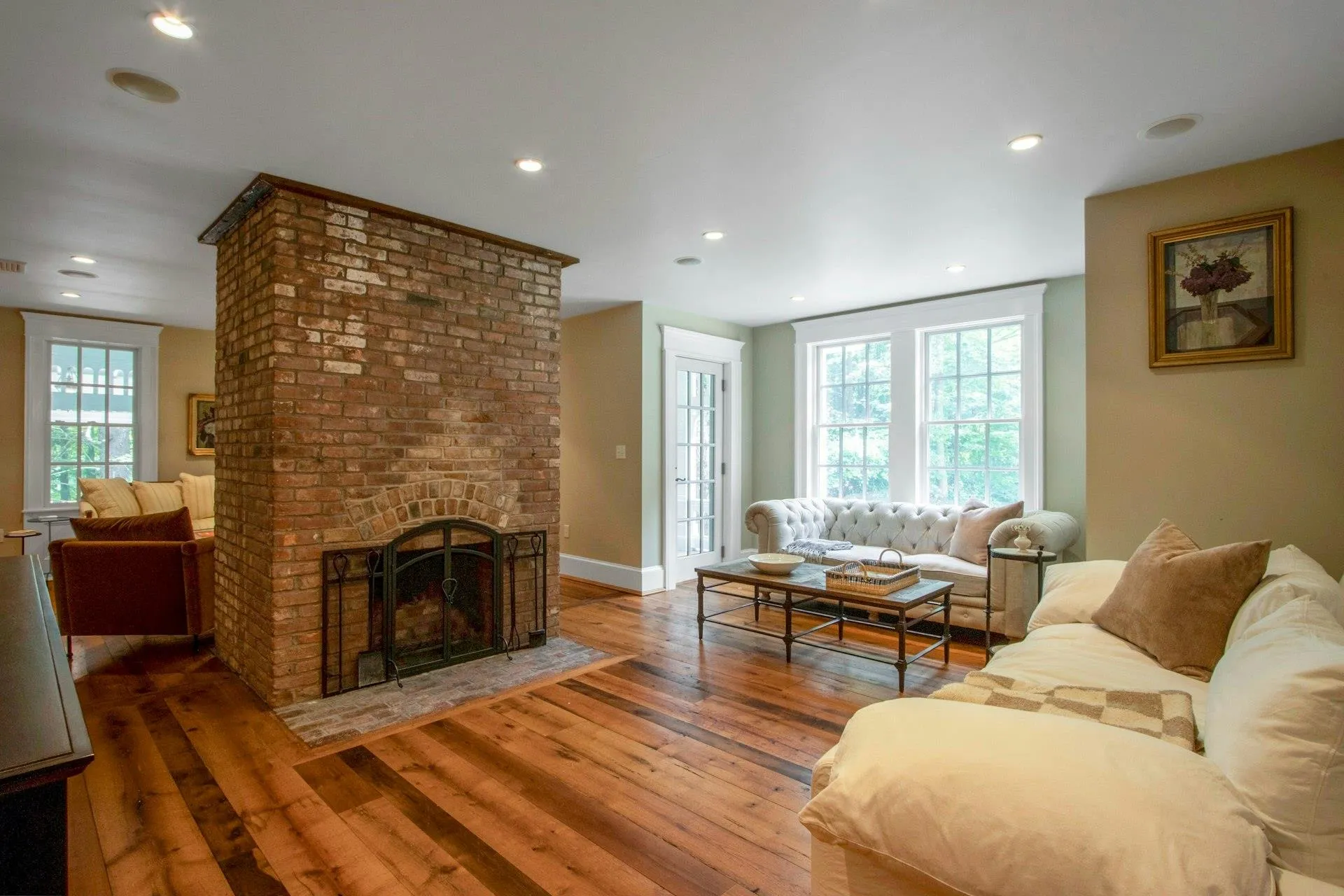 Living area with hardwood / wood-style floors, a brick fireplace, recessed lighting, and baseboards Living area with hardwood / wood-style floors, a brick fireplace, recessed lighting, and baseboards