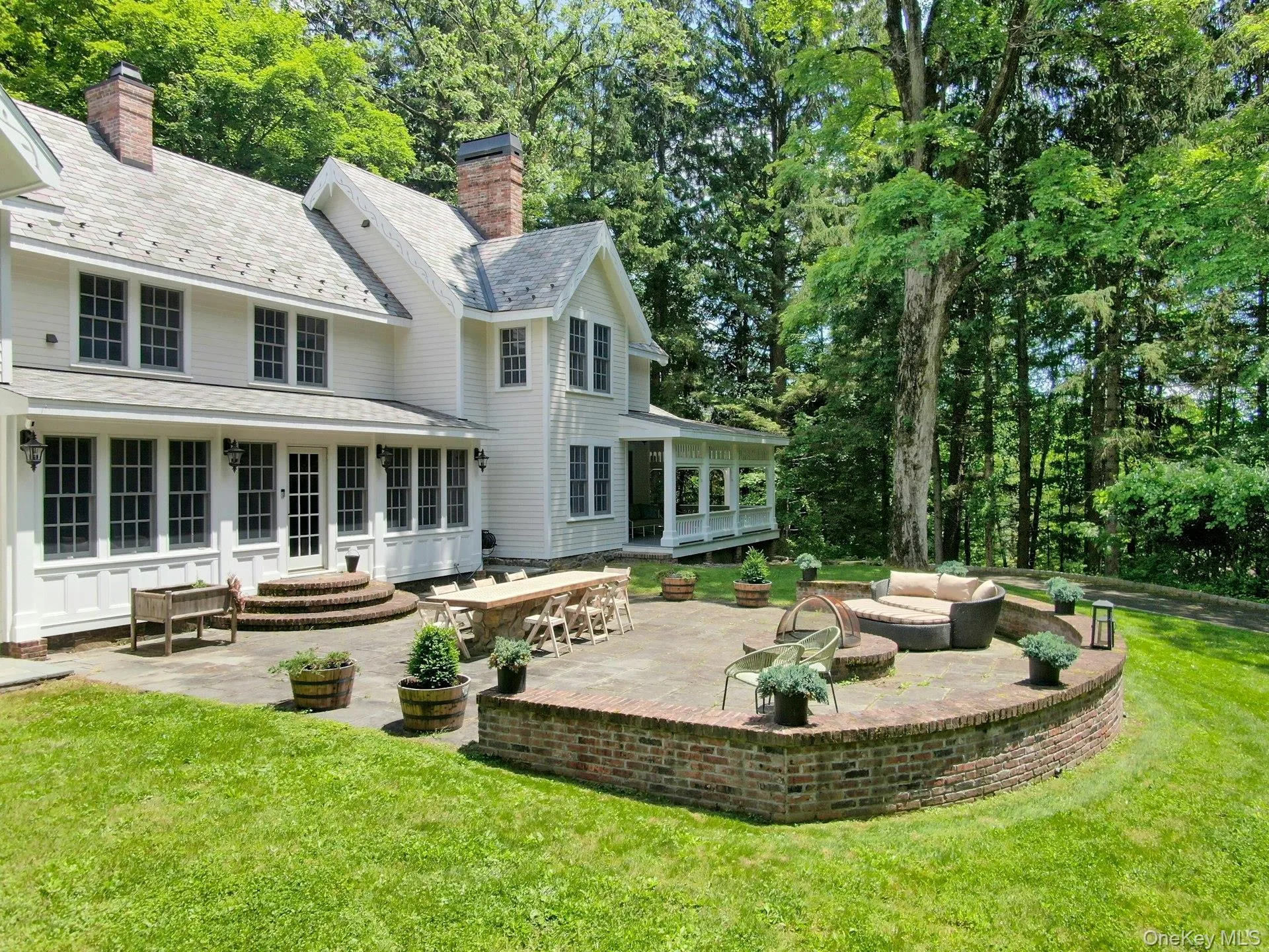 Back of house with a sunroom, a patio, a lawn, outdoor lounge area, and a high end roof Back of house with a sunroom, a patio, a lawn, outdoor lounge area, and a high end roof