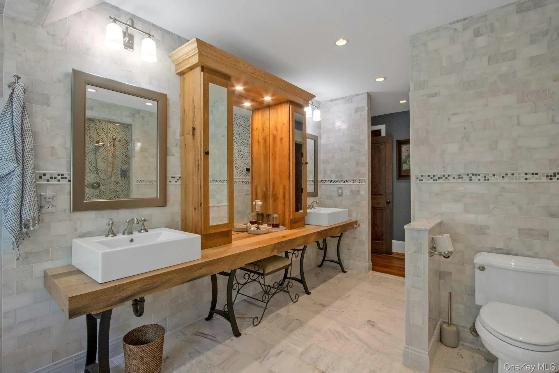 Bathroom featuring tile walls, toilet, recessed lighting, and dual sinks Bathroom featuring tile walls, toilet, recessed lighting, and dual sinks