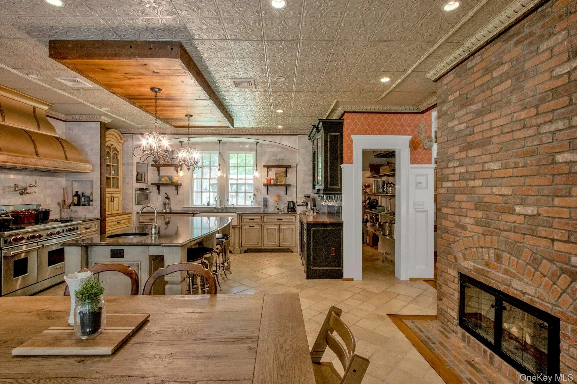 Kitchen featuring range with two ovens, open shelves, a sink, a breakfast bar, and dark countertops Kitchen featuring range with two ovens, open shelves, a sink, a breakfast bar, and dark countertops