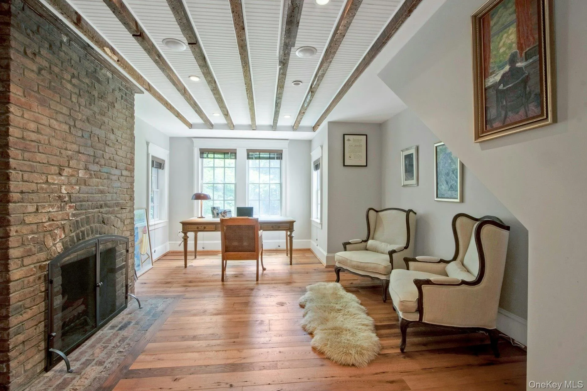 Living area with light wood finished floors, a brick fireplace, baseboards, an office area, and recessed lighting Living area with light wood finished floors, a brick fireplace, baseboards, an office area, and recessed lighting