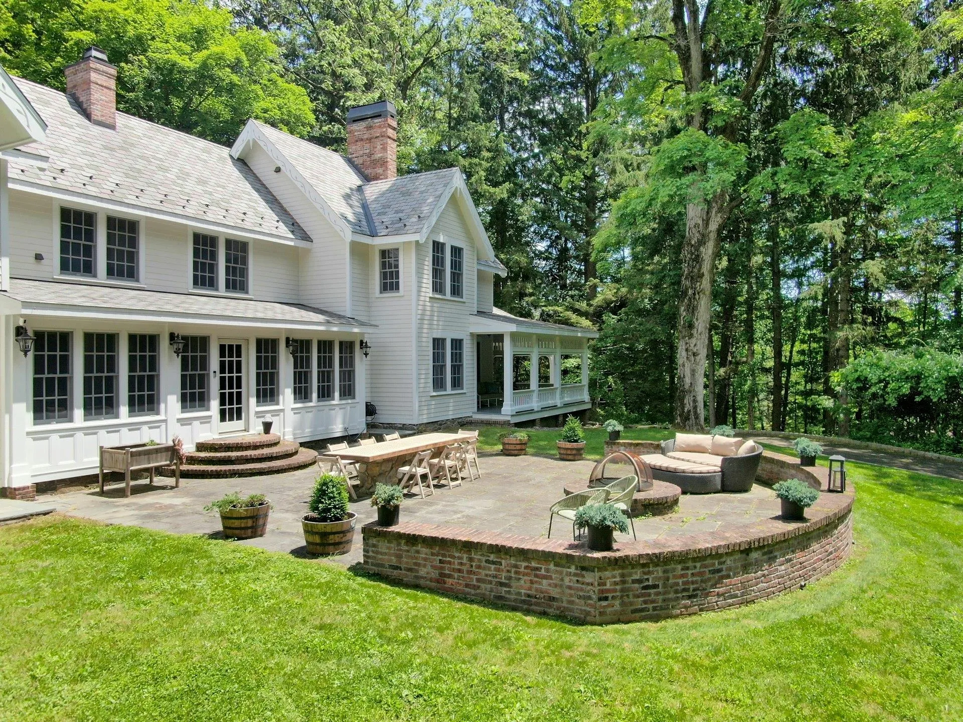 Back of house with a sunroom, a patio, a lawn, outdoor lounge area, and a high end roof Back of house with a sunroom, a patio, a lawn, outdoor lounge area, and a high end roof