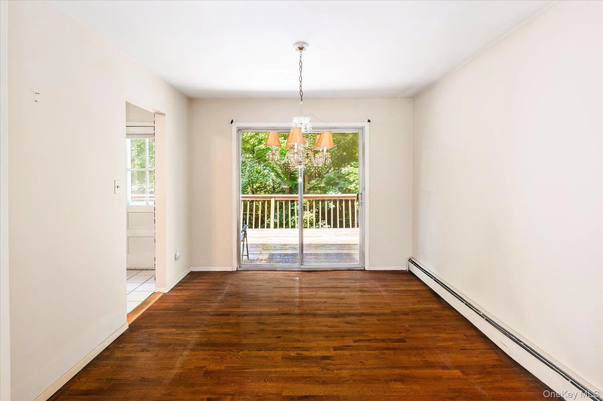 Dining Room with Sliders to the Deck and Opening to the Kitchen Dining Room with Sliders to the Deck and Opening to the Kitchen