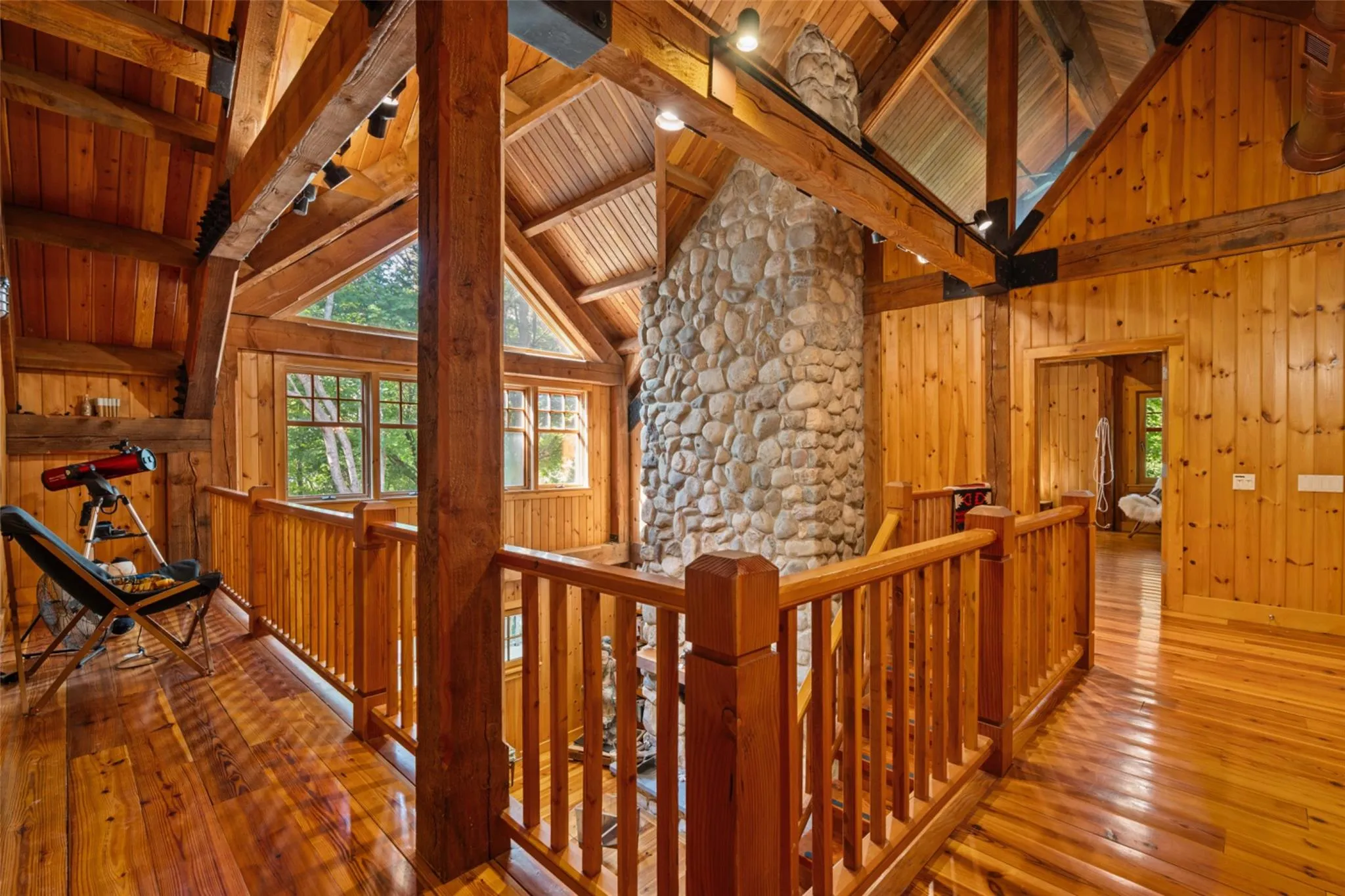 Hall with an upstairs landing, hardwood / wood-style floors, wood ceiling, and wood walls Hall with an upstairs landing, hardwood / wood-style floors, wood ceiling, and wood walls