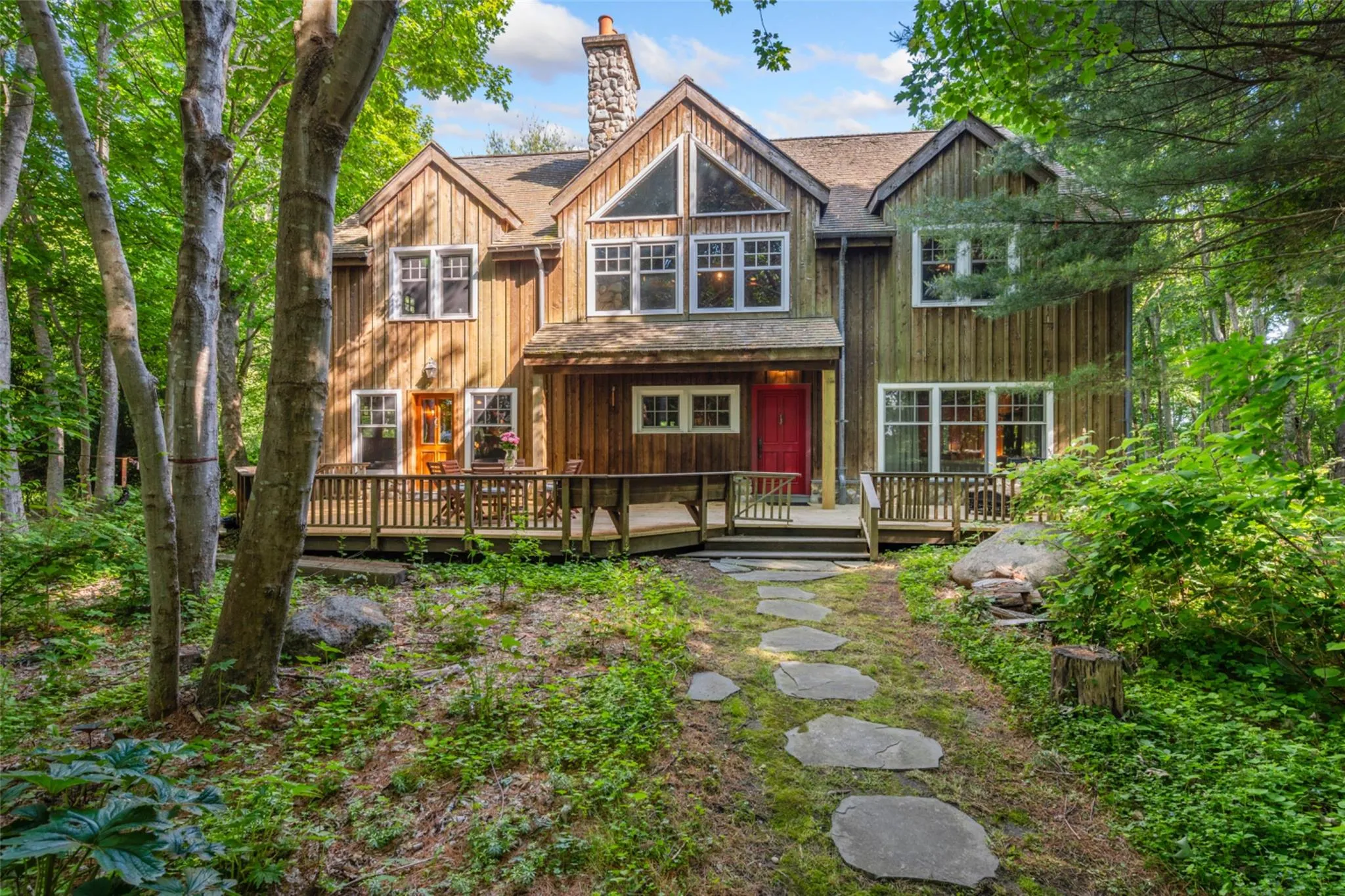 View of front facade with a chimney, a deck, and roof with shingles View of front facade with a chimney, a deck, and roof with shingles
