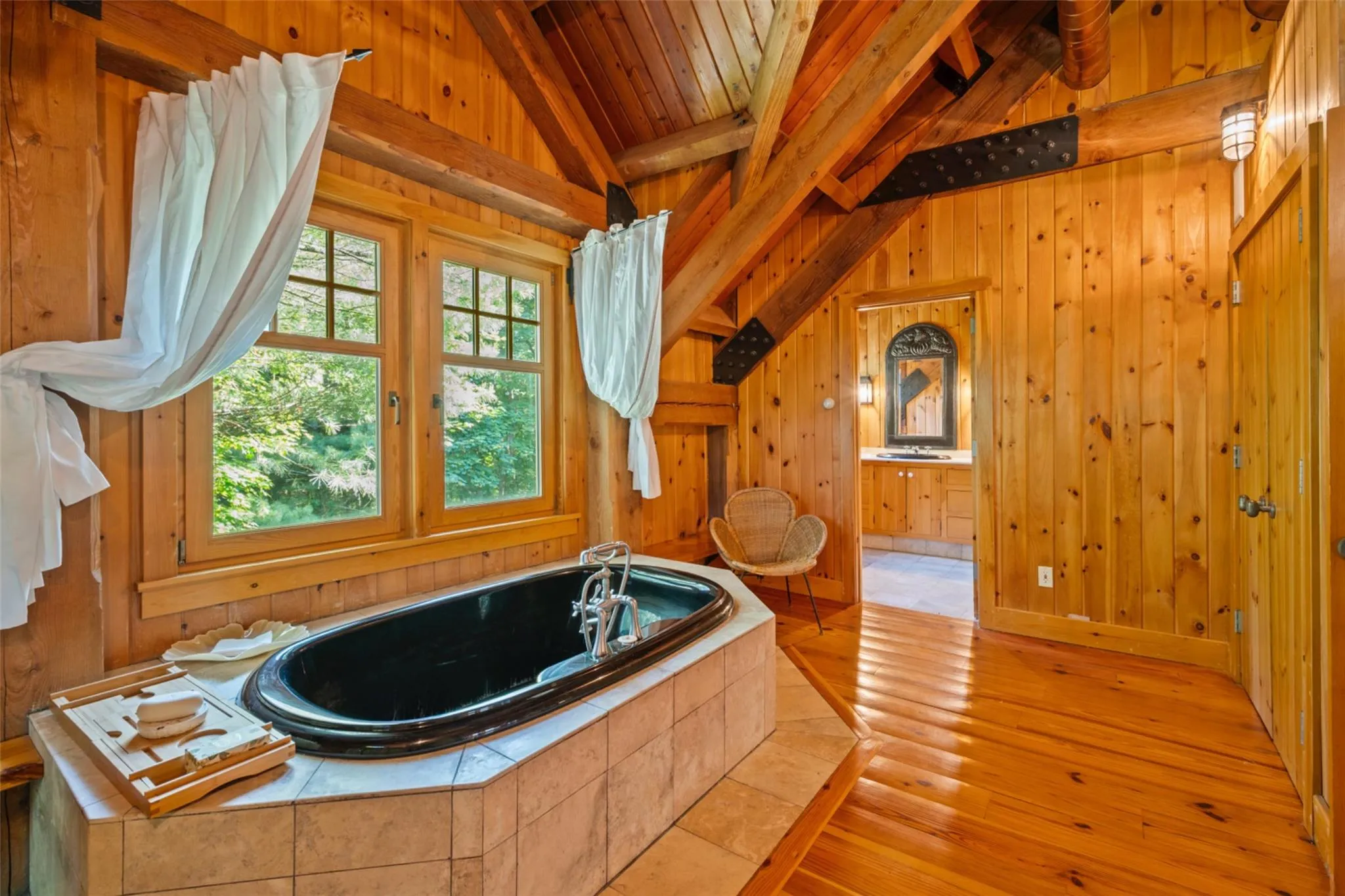Full bathroom featuring wooden walls, a bath, vanity, wood-type flooring, and wooden ceiling Full bathroom featuring wooden walls, a bath, vanity, wood-type flooring, and wooden ceiling