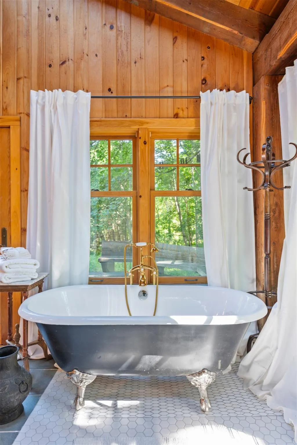 Bathroom with wooden walls, a freestanding tub, and tile patterned flooring Bathroom with wooden walls, a freestanding tub, and tile patterned flooring