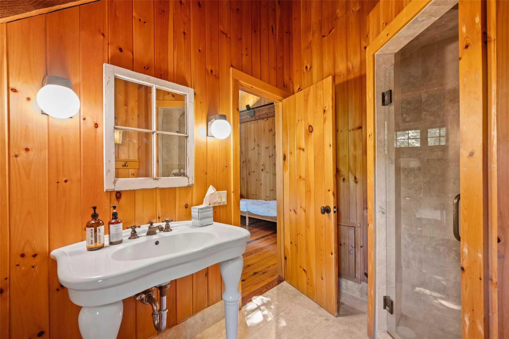 Bathroom with wood walls and a shower stall Bathroom with wood walls and a shower stall