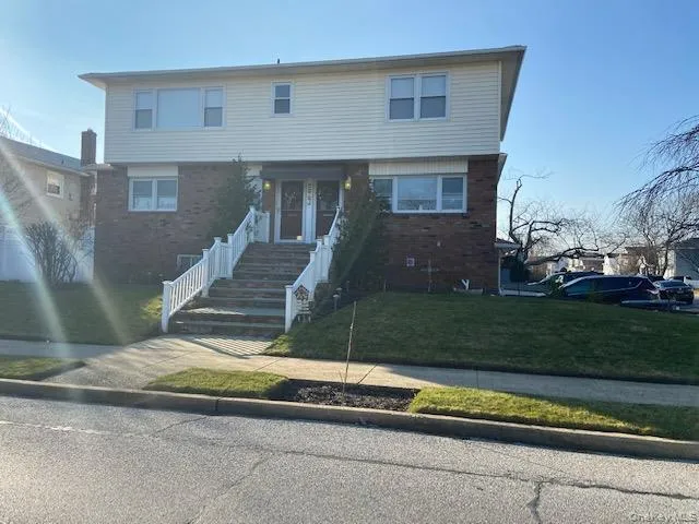 View of front of property with brick siding and a front yard View of front of property with brick siding and a front yard