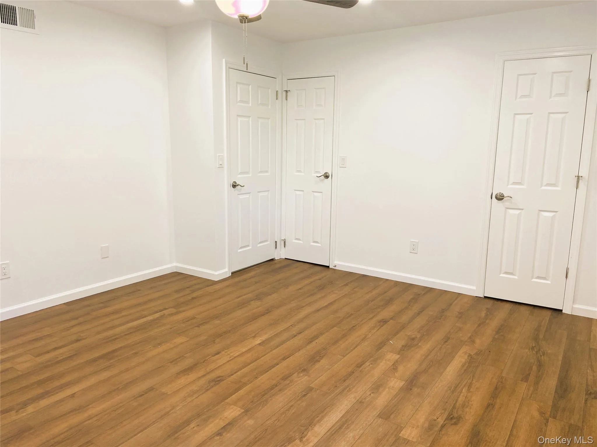 Unfurnished bedroom with wood finished floors, baseboards, and a ceiling fan Unfurnished bedroom with wood finished floors, baseboards, and a ceiling fan