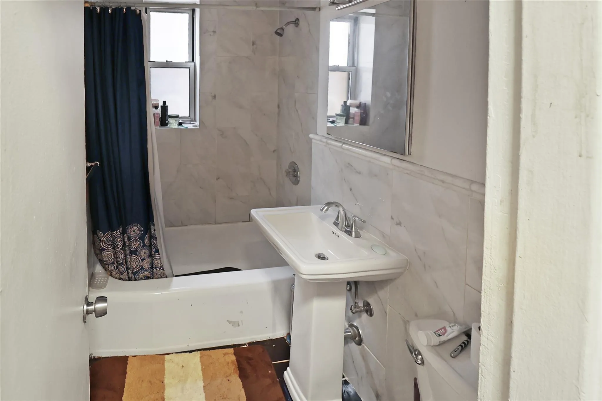 Full bathroom with plenty of natural light, shower / tub combo, toilet, and tile walls Full bathroom with plenty of natural light, shower / tub combo, toilet, and tile walls