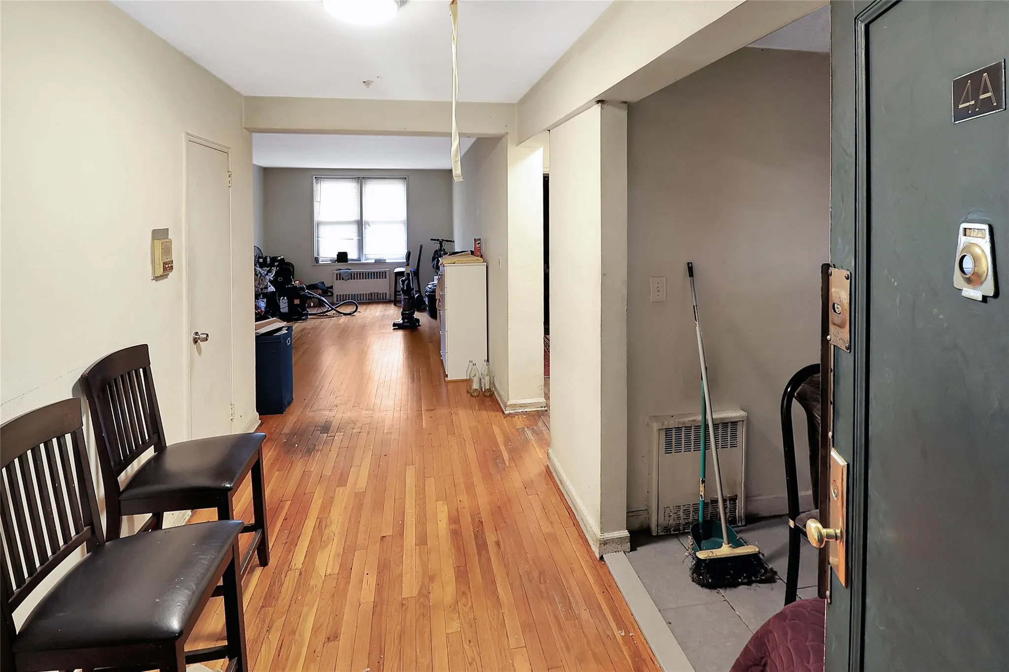 Hall with light wood-style floors, radiator heating unit, and an office area Hall with light wood-style floors, radiator heating unit, and an office area