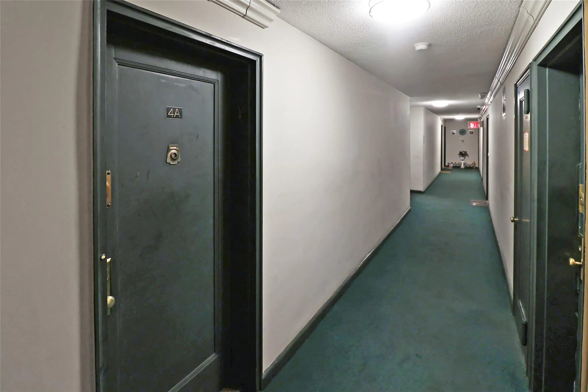Hallway featuring a textured ceiling and baseboards Hallway featuring a textured ceiling and baseboards