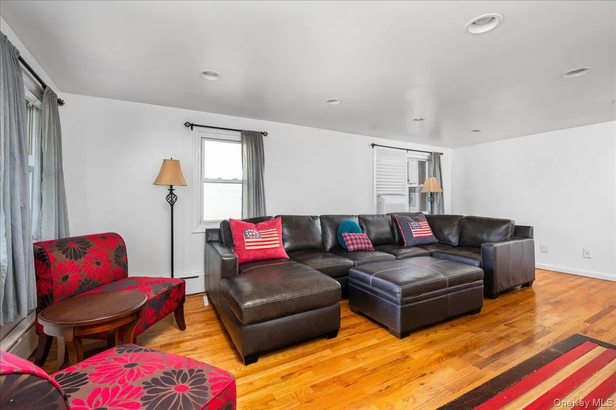 Living room with wood finished floors, a baseboard radiator, and recessed lighting Living room with wood finished floors, a baseboard radiator, and recessed lighting
