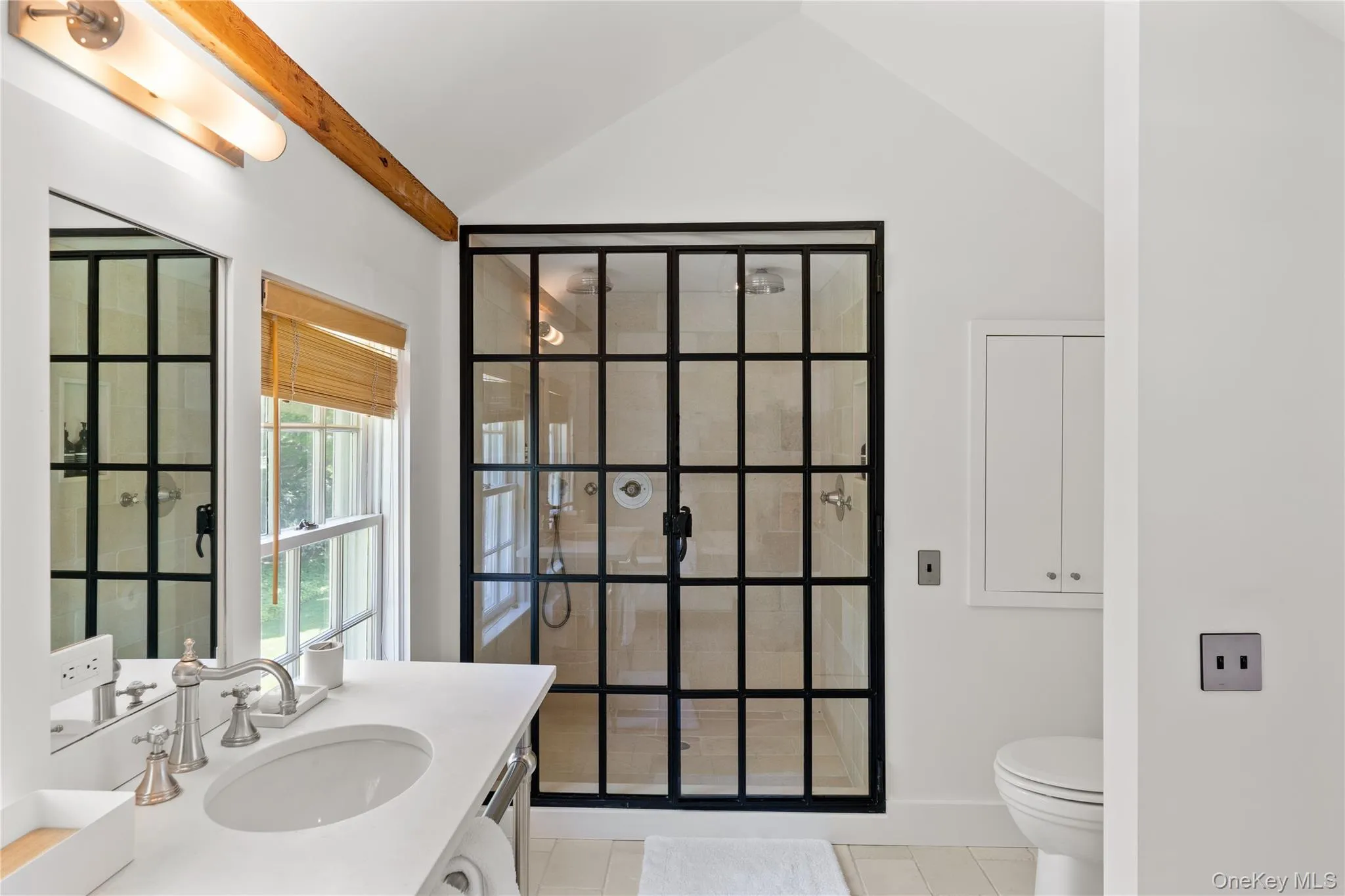 Bathroom with vanity, toilet, vaulted ceiling, tile patterned floors, and a walk in shower Bathroom with vanity, toilet, vaulted ceiling, tile patterned floors, and a walk in shower