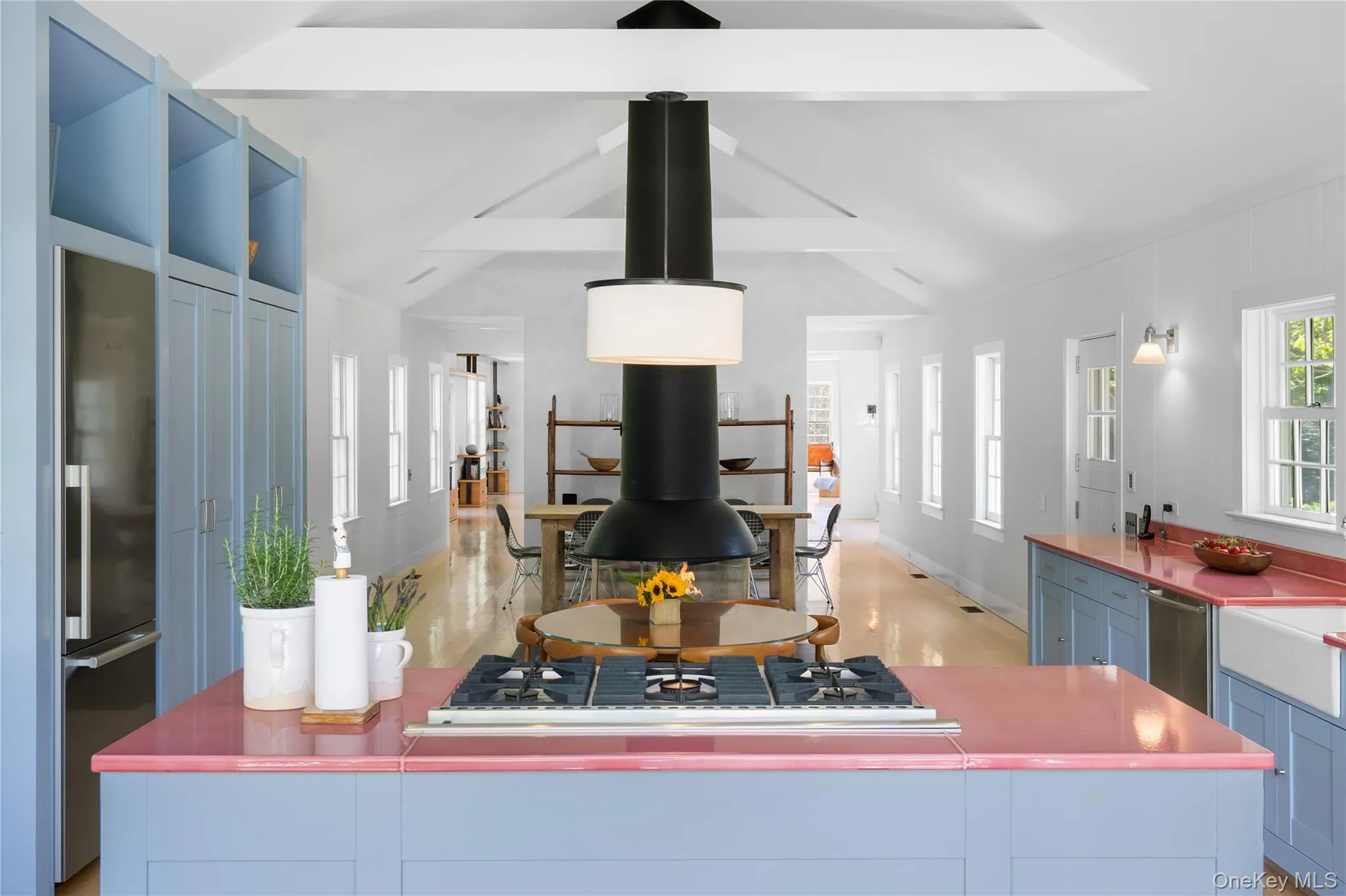 Kitchen with stainless steel appliances, light wood finished floors, blue cabinetry, and baseboards Kitchen with stainless steel appliances, light wood finished floors, blue cabinetry, and baseboards