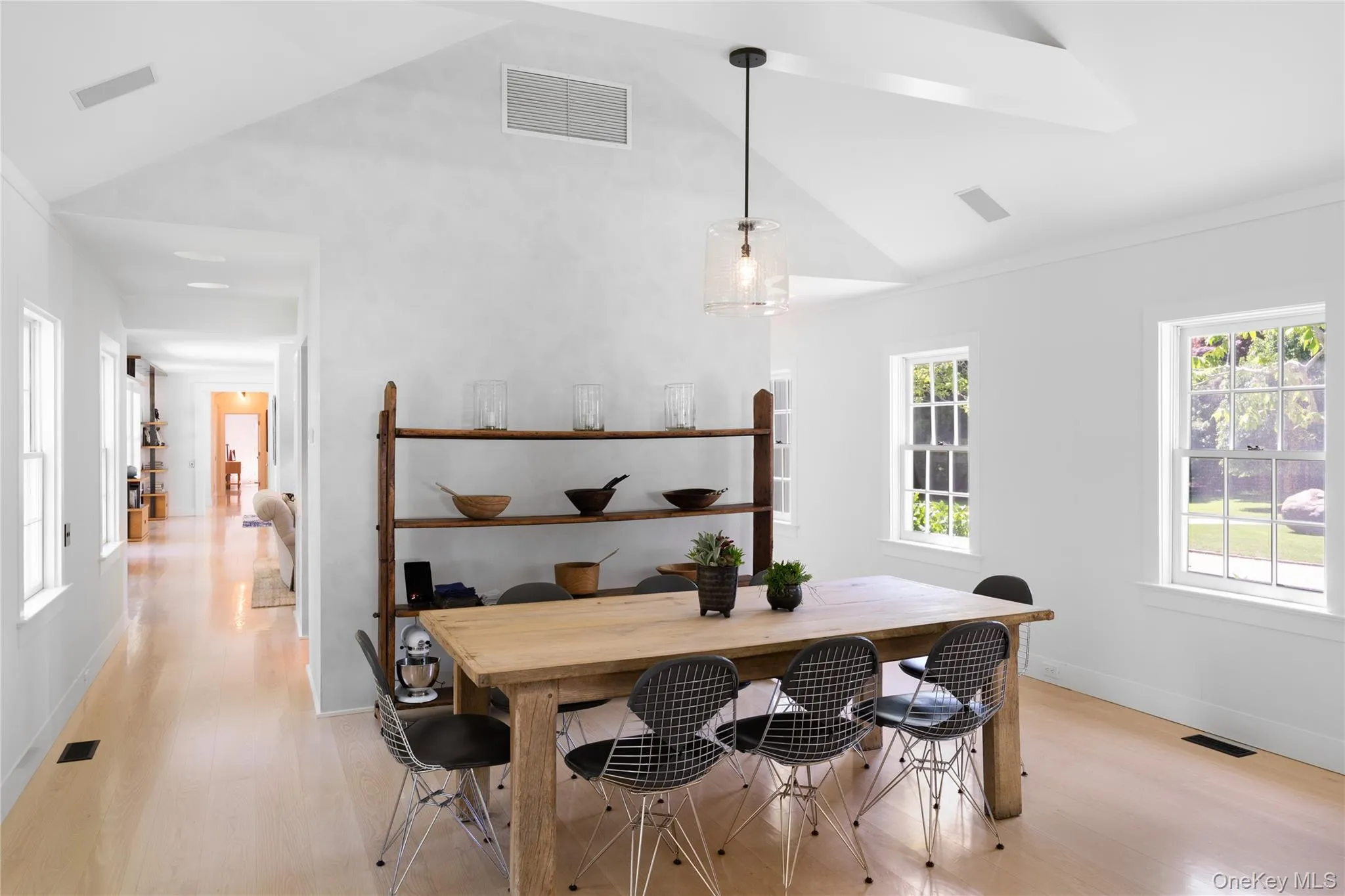 Dining room featuring light wood finished floors, baseboards, and high vaulted ceiling Dining room featuring light wood finished floors, baseboards, and high vaulted ceiling