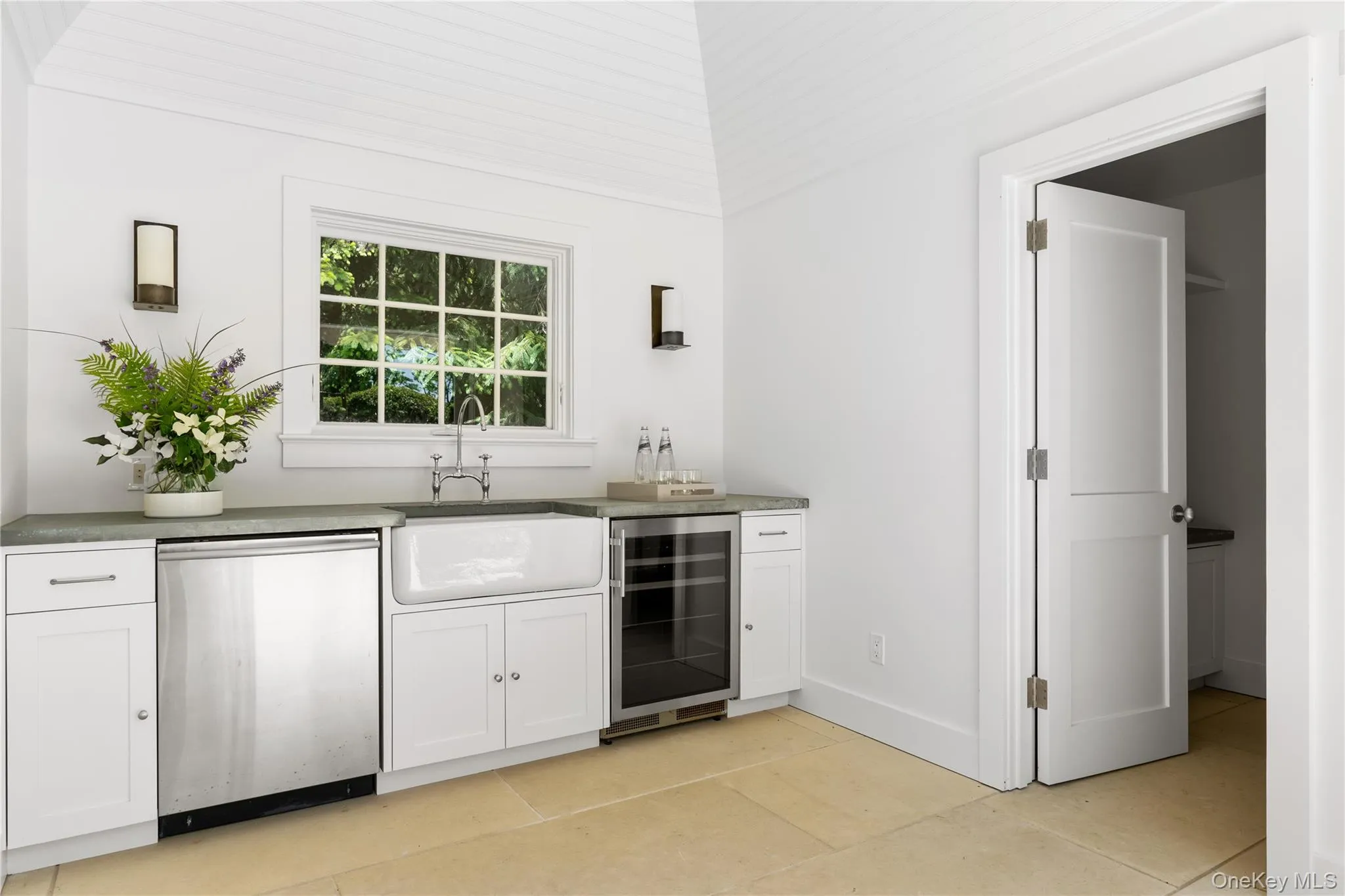 Indoor wet bar featuring wine cooler, dishwasher, light tile patterned flooring, and baseboards Indoor wet bar featuring wine cooler, dishwasher, light tile patterned flooring, and baseboards