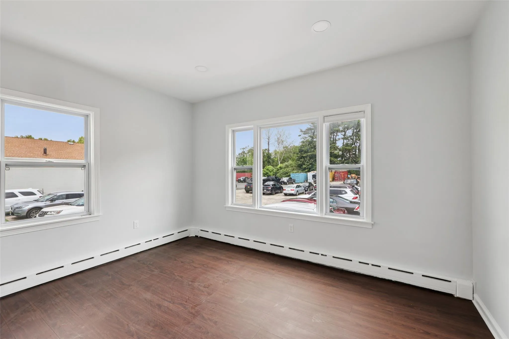Spare room with a baseboard heating unit and dark wood-type flooring Spare room with a baseboard heating unit and dark wood-type flooring