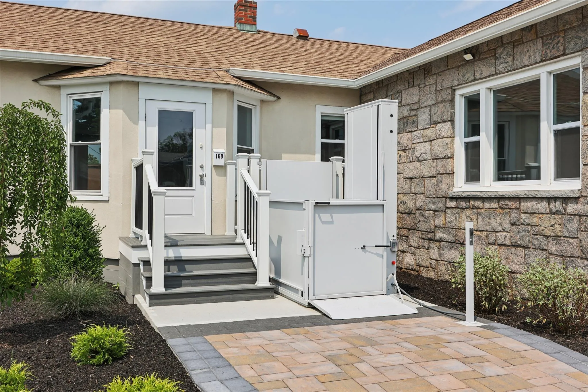 Entrance to property featuring roof with shingles, a chimney, stone siding, and stucco siding Entrance to property featuring roof with shingles, a chimney, stone siding, and stucco siding