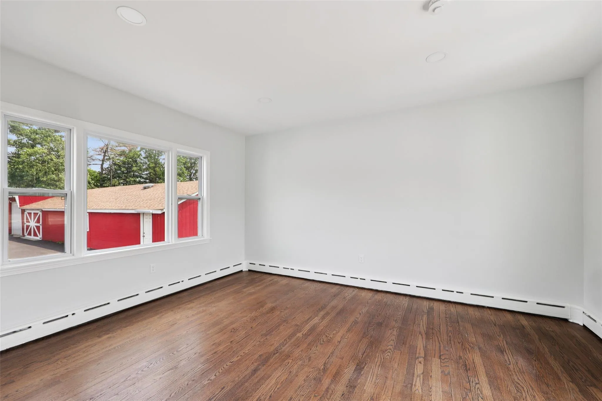Spare room with wood finished floors, a baseboard heating unit, and recessed lighting Spare room with wood finished floors, a baseboard heating unit, and recessed lighting