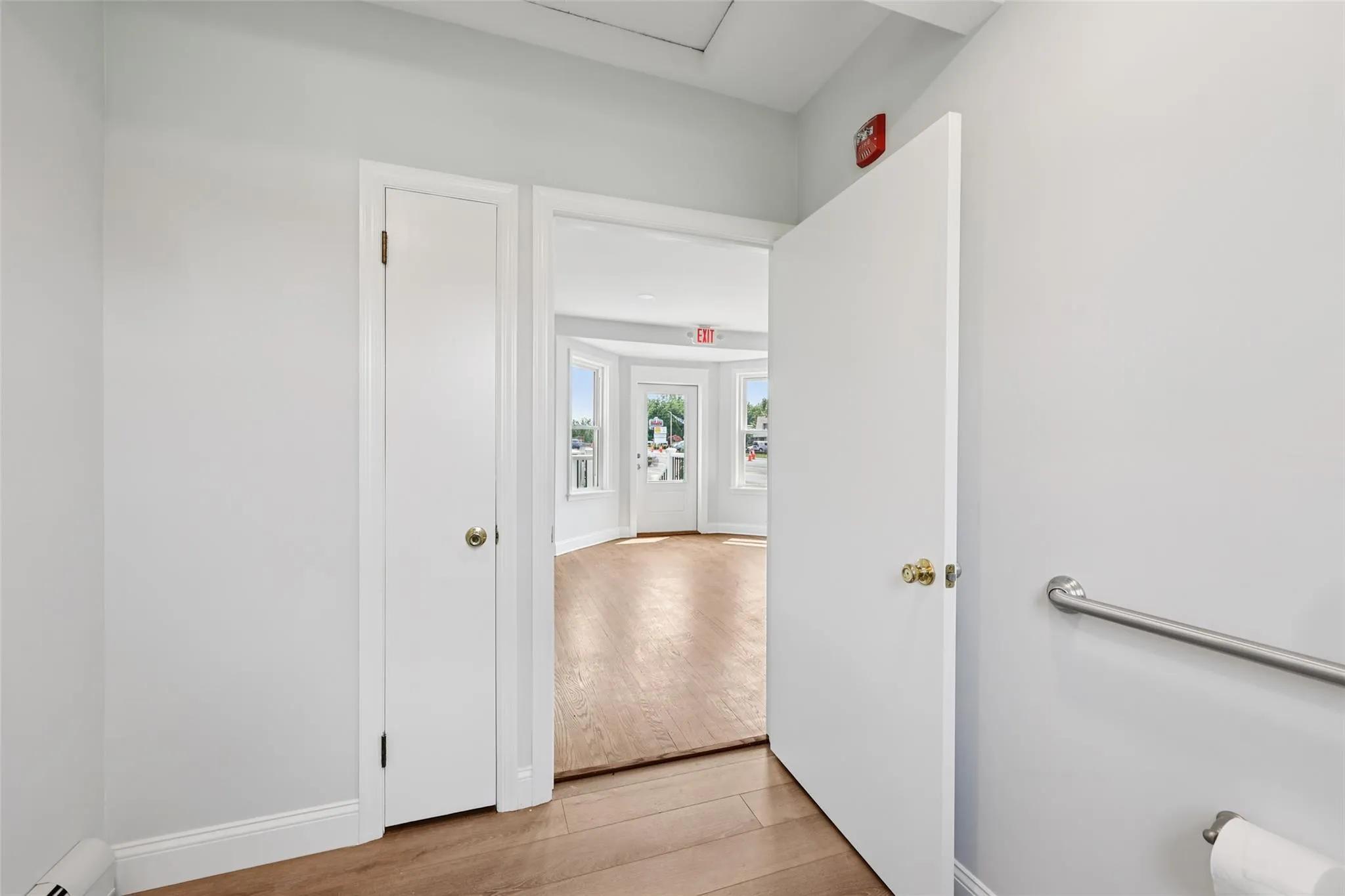 Hall featuring a baseboard radiator and light wood finished floors Hall featuring a baseboard radiator and light wood finished floors