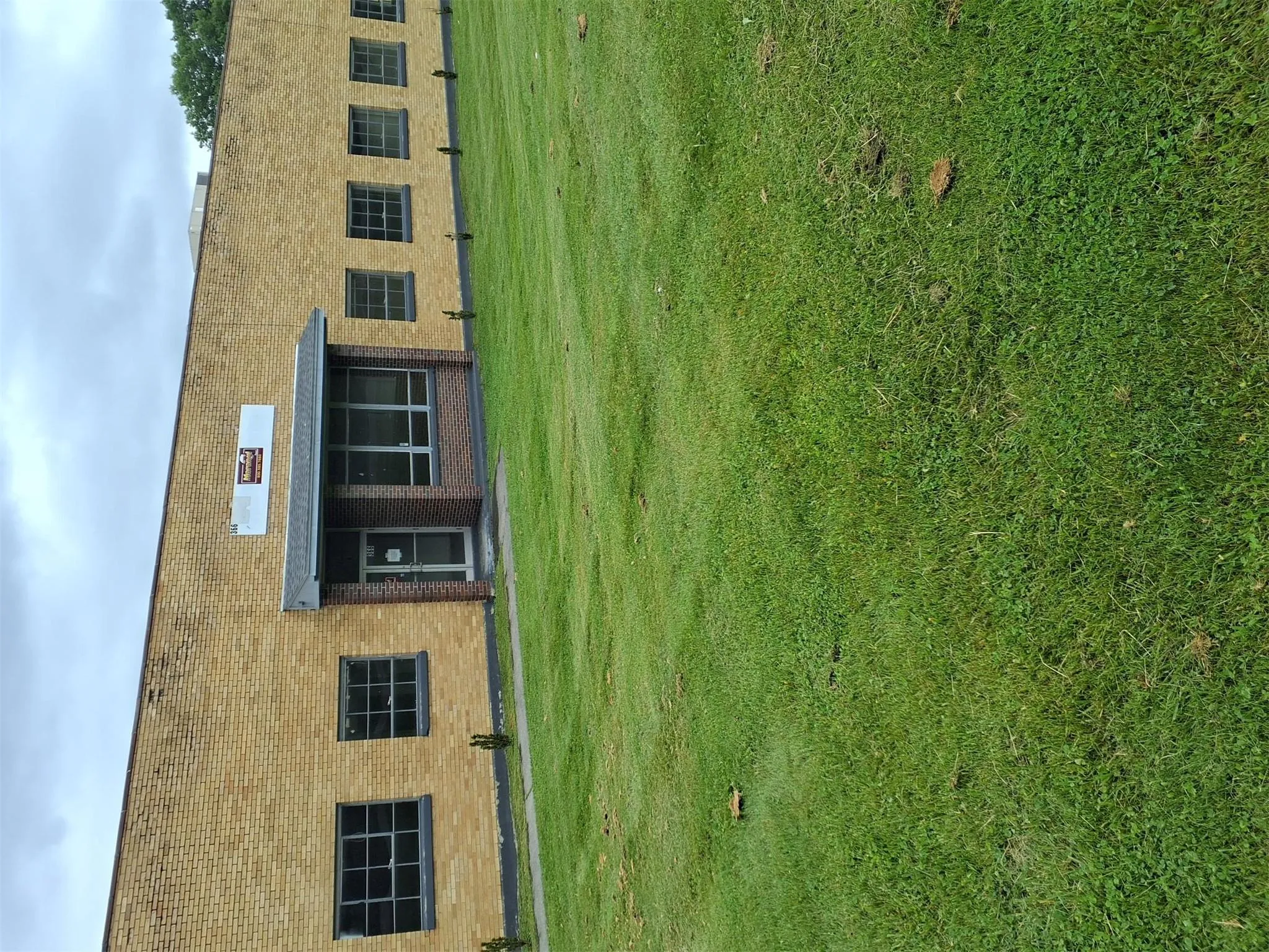 Back of property with a yard and brick siding Back of property with a yard and brick siding