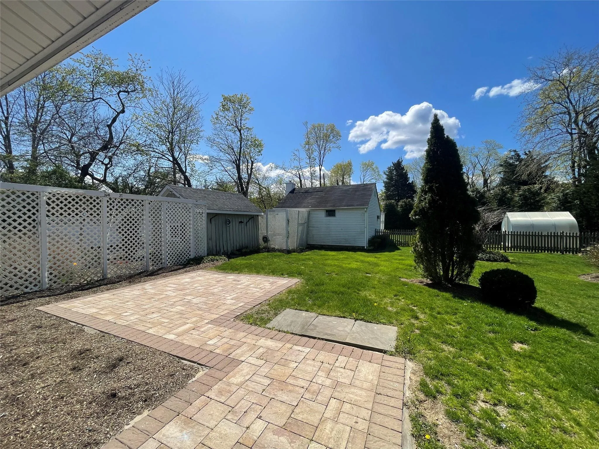Fenced backyard featuring an outdoor structure and a patio Fenced backyard featuring an outdoor structure and a patio
