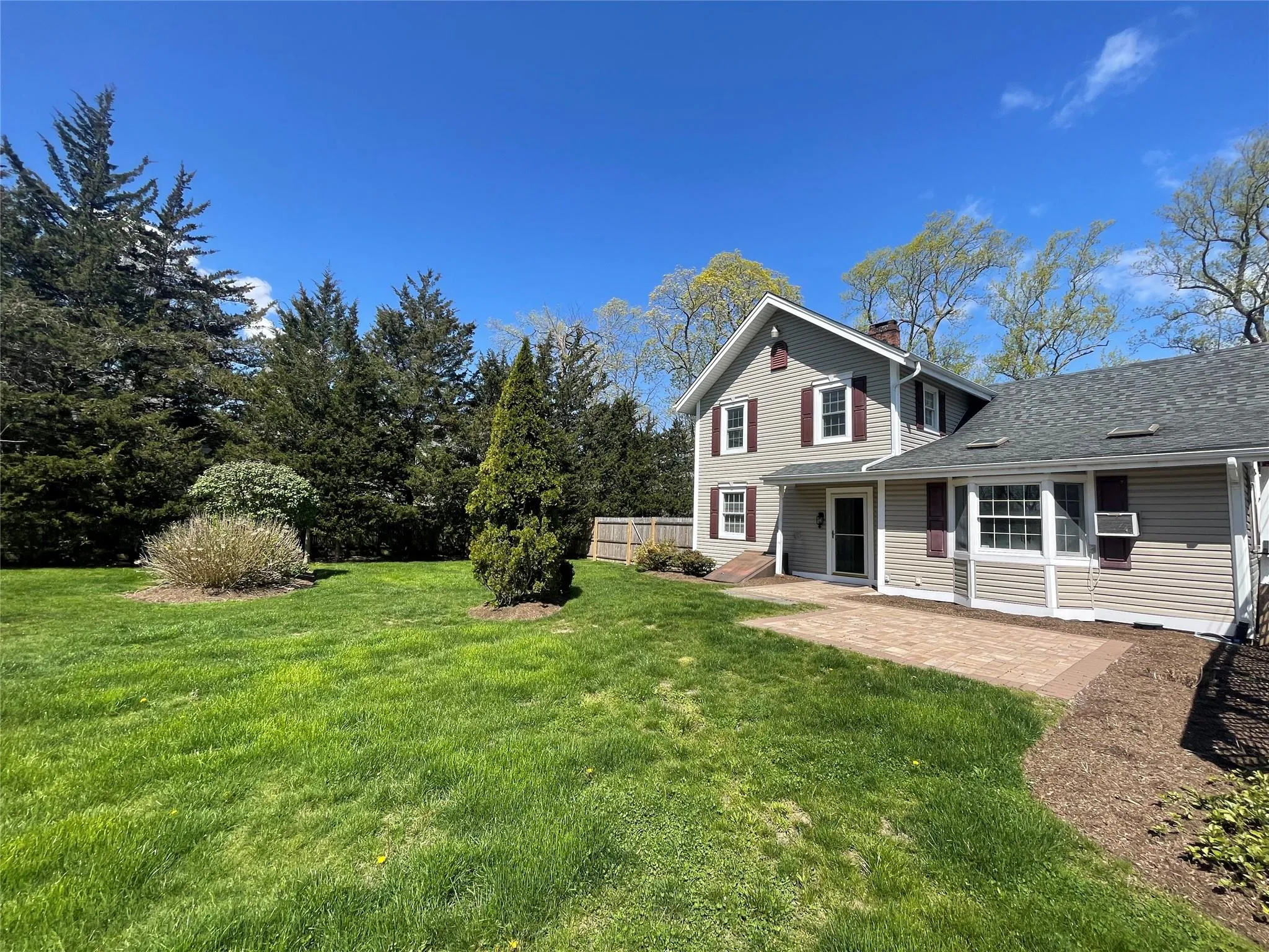 View of grassy yard featuring a patio area View of grassy yard featuring a patio area