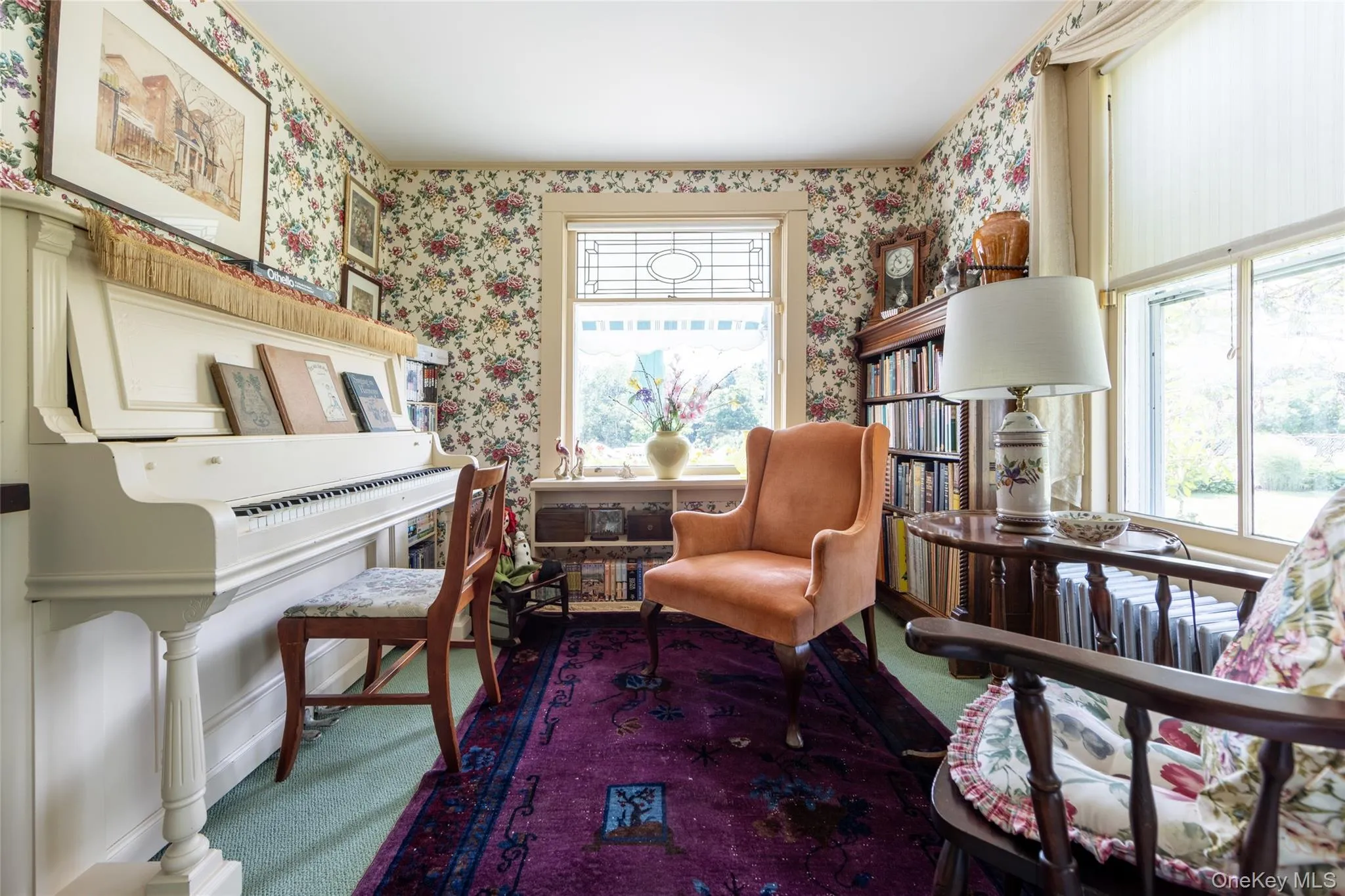 Living area with wallpapered walls and carpet flooring Living area with wallpapered walls and carpet flooring