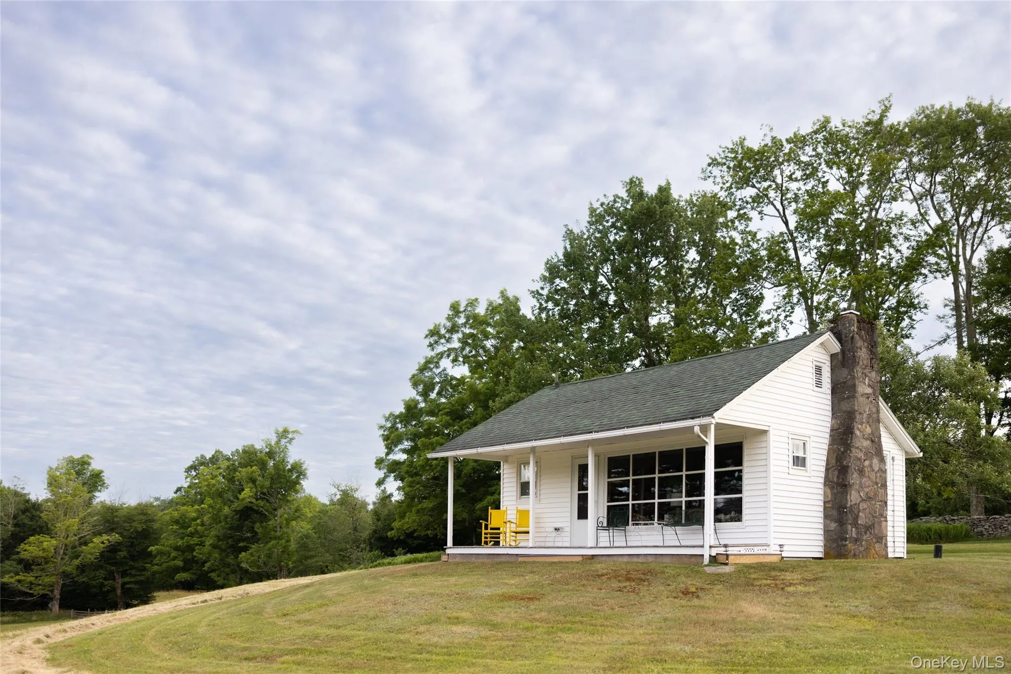 View of front of property featuring a front lawn, a chimney, roof with shingles, and covered porch View of front of property featuring a front lawn, a chimney, roof with shingles, and covered porch