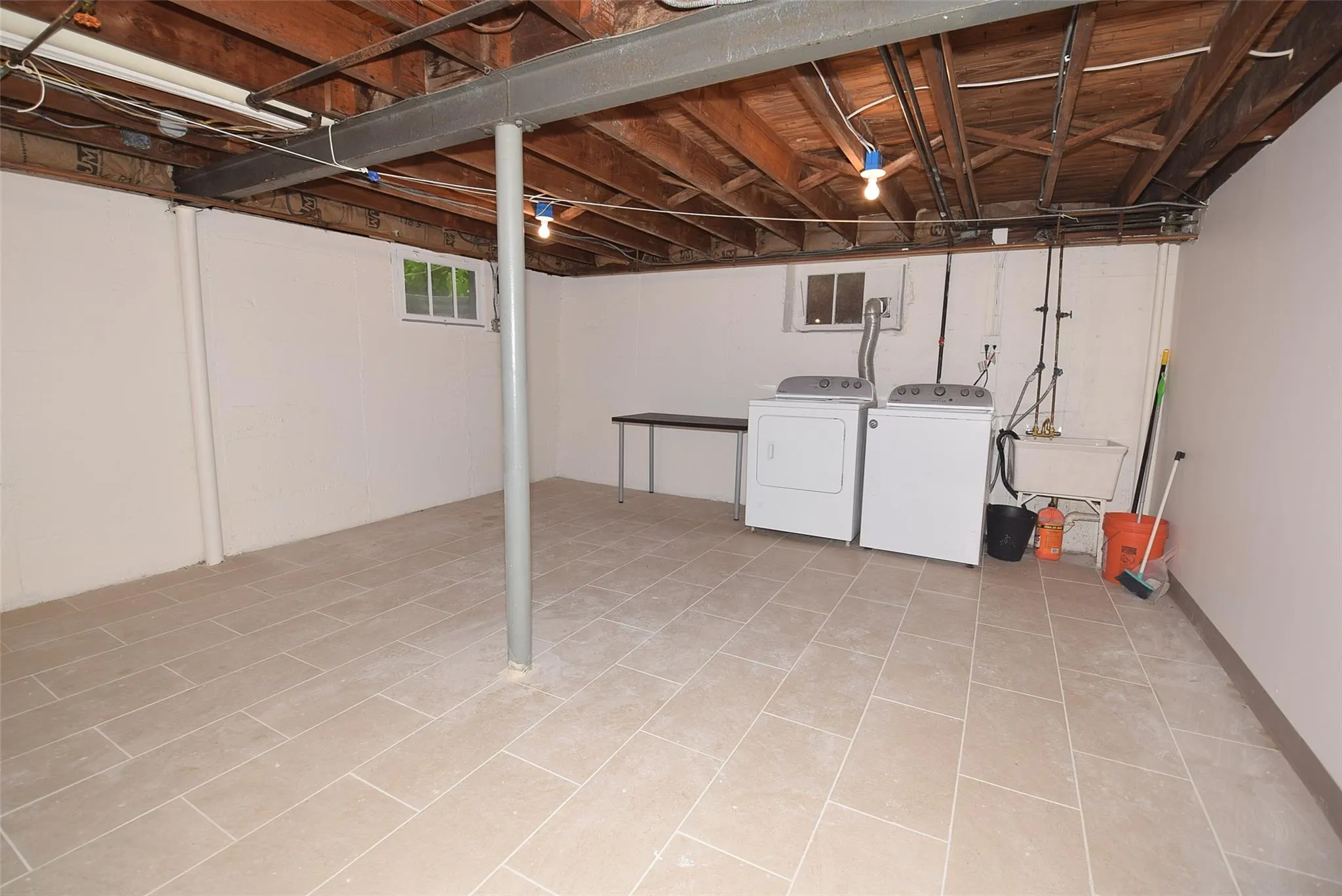 Below grade area featuring washing machine and dryer and a sink Below grade area featuring washing machine and dryer and a sink