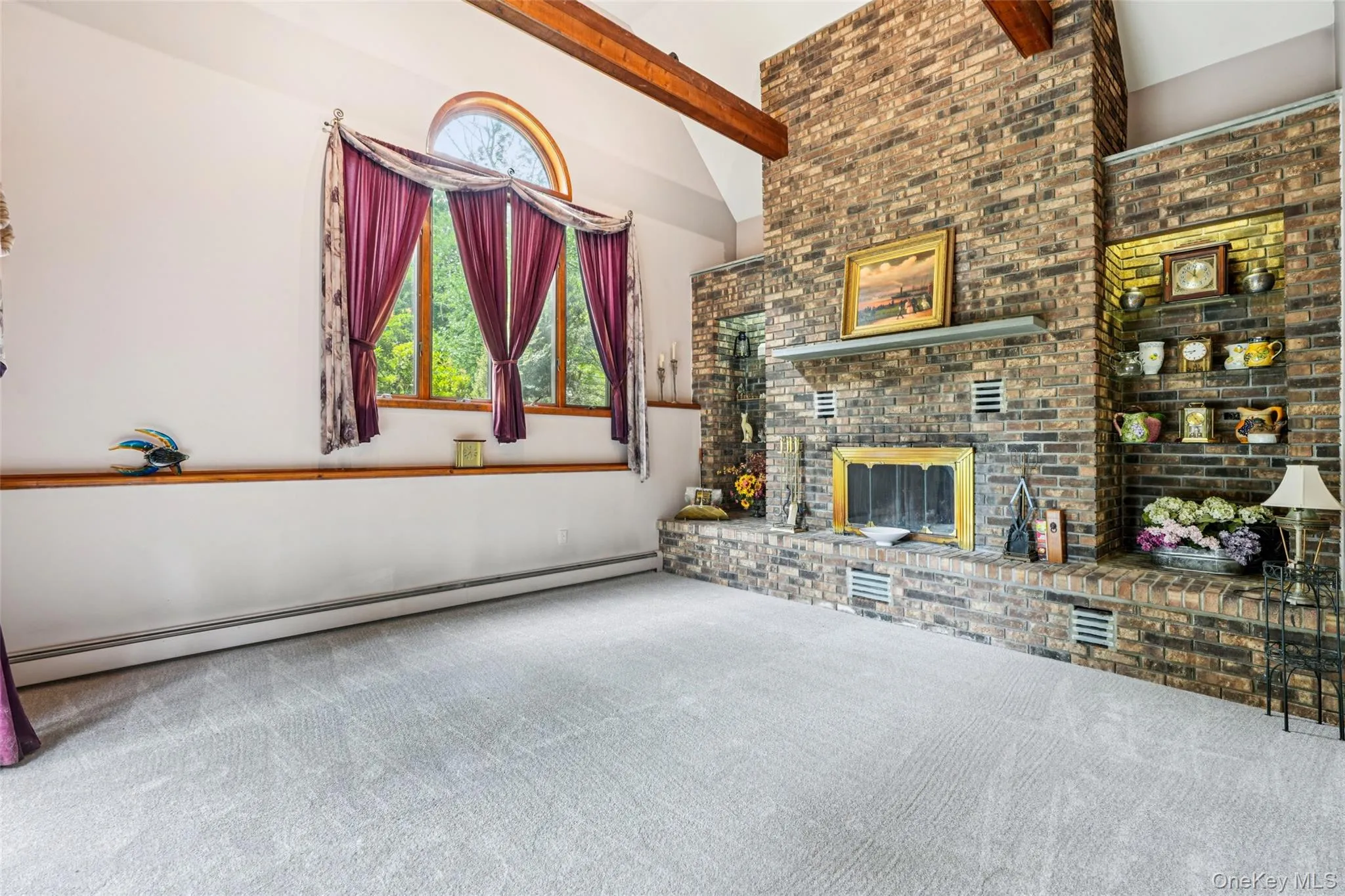 Unfurnished living room featuring carpet, baseboard heating, a fireplace, beamed ceiling, and high vaulted ceiling Unfurnished living room featuring carpet, baseboard heating, a fireplace, beamed ceiling, and high vaulted ceiling