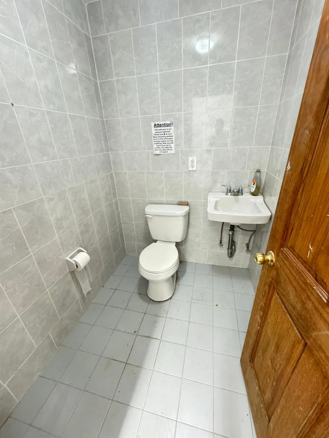 Half bath with toilet, tile walls, tile patterned floors, and a sink Half bath with toilet, tile walls, tile patterned floors, and a sink