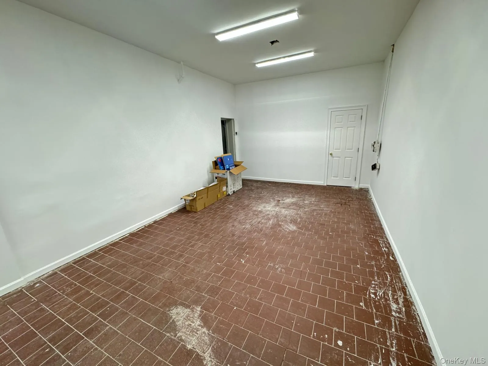 Empty room featuring brick patterned floors and baseboards Empty room featuring brick patterned floors and baseboards