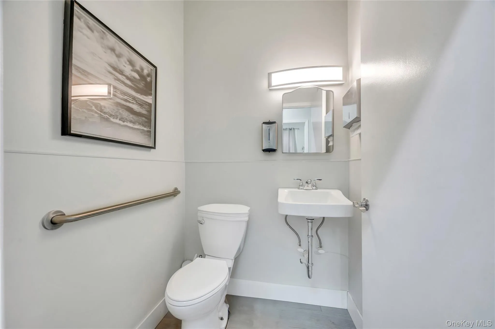 Bathroom with toilet, baseboards, and a sink Bathroom with toilet, baseboards, and a sink