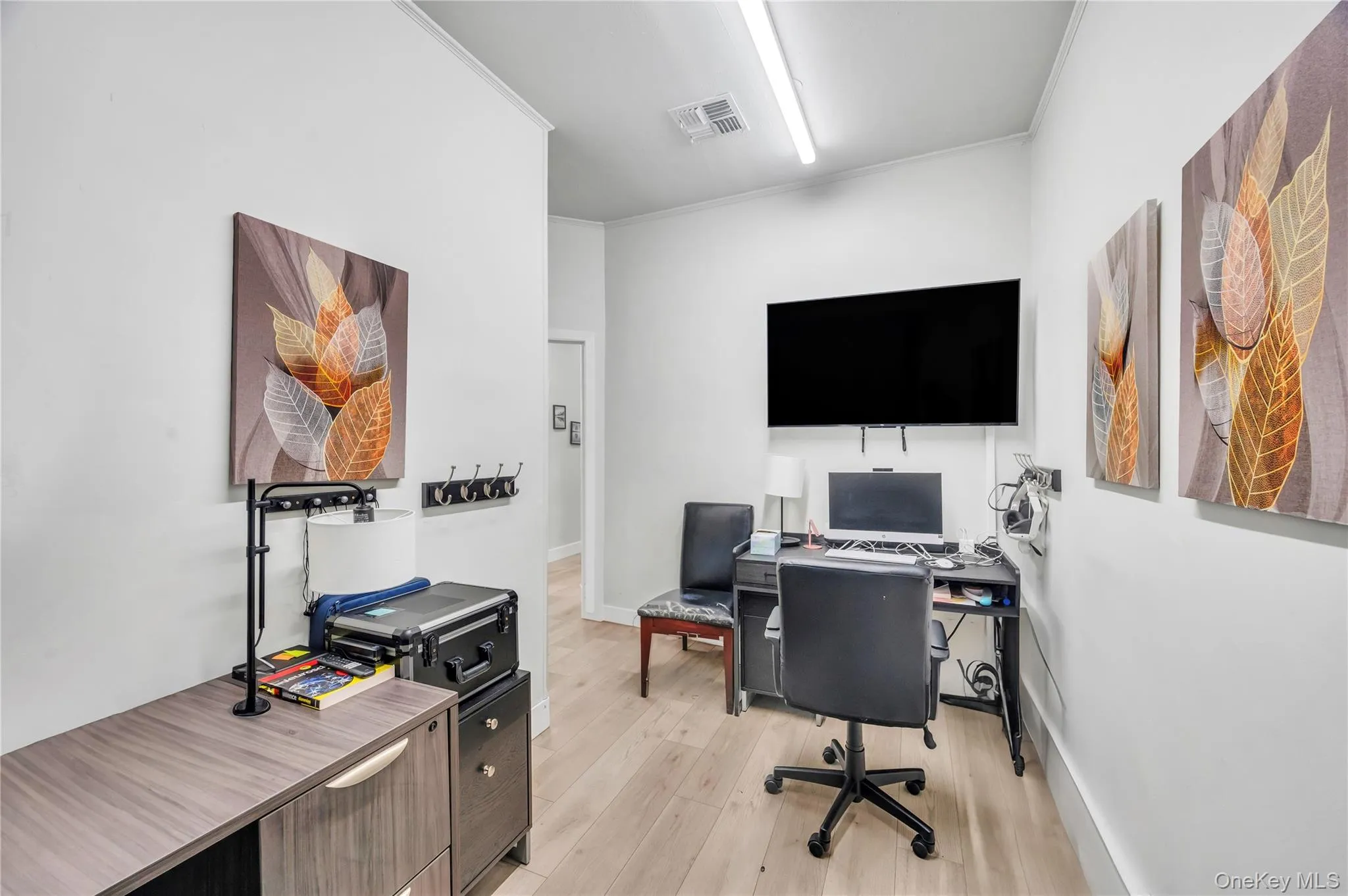 Home office with light wood-type flooring, crown molding, and baseboards Home office with light wood-type flooring, crown molding, and baseboards