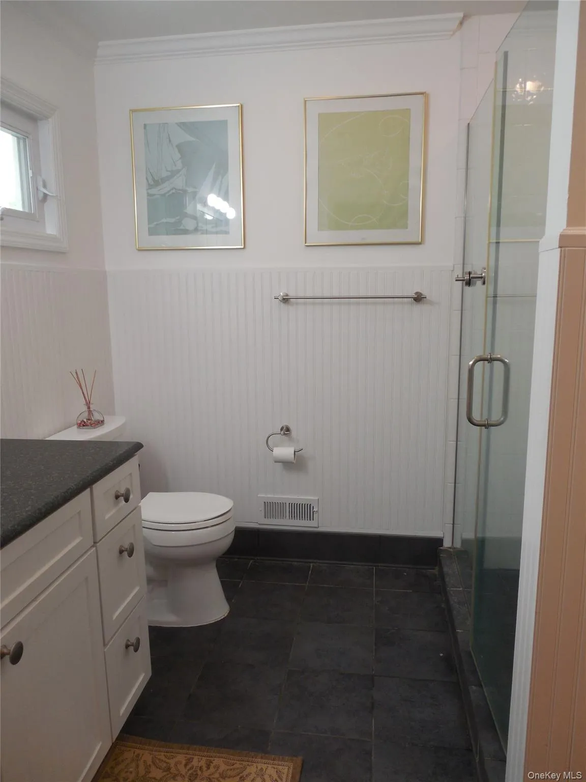 Bathroom featuring wainscoting, vanity, toilet, a stall shower, and crown molding Bathroom featuring wainscoting, vanity, toilet, a stall shower, and crown molding