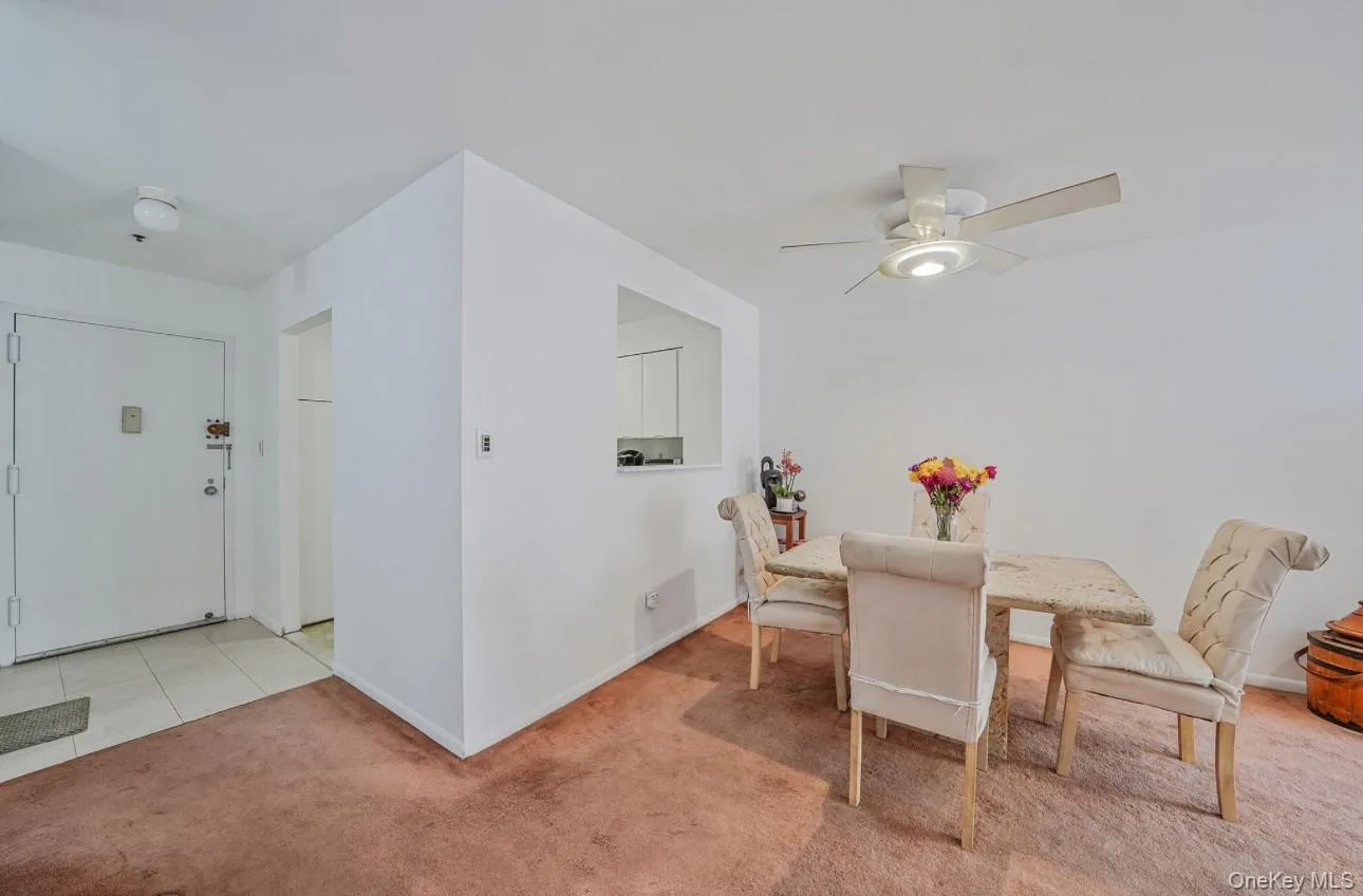 Dining room with light carpet, light tile patterned floors, and ceiling fan Dining room with light carpet, light tile patterned floors, and ceiling fan