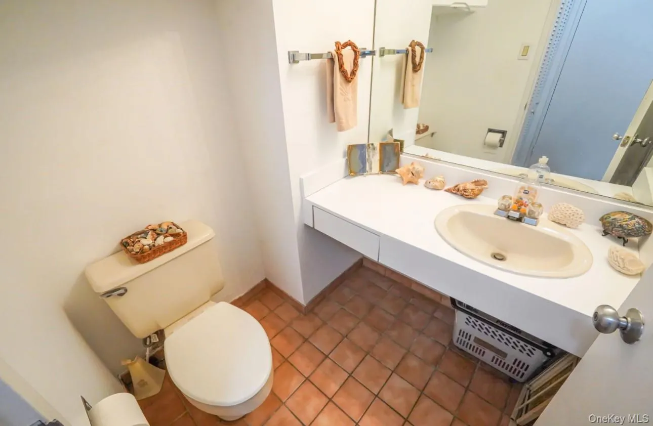 Half bathroom with dark tile patterned flooring and vanity Half bathroom with dark tile patterned flooring and vanity