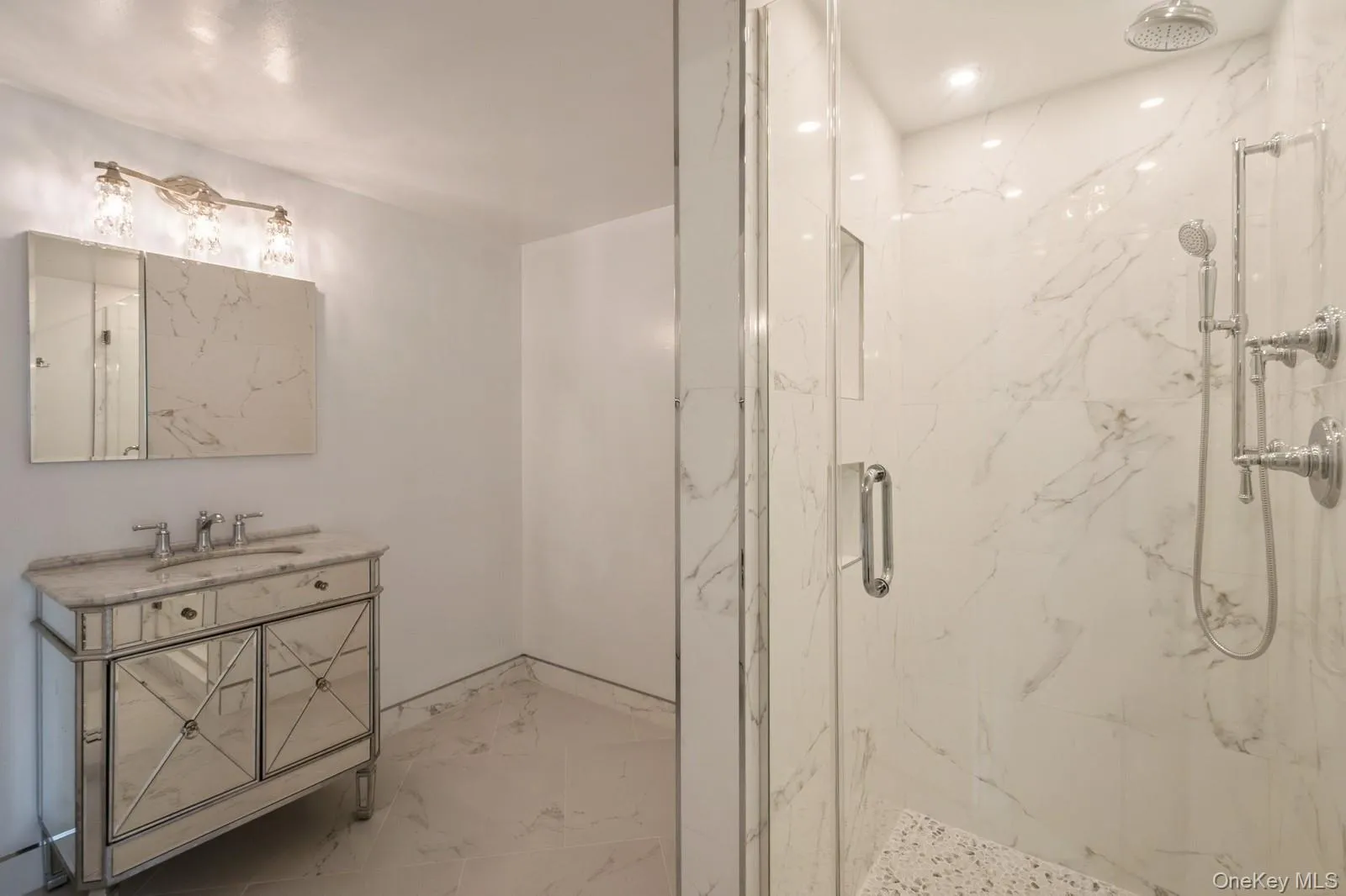 Full bath featuring a marble finish shower, marble finish flooring, and vanity Full bath featuring a marble finish shower, marble finish flooring, and vanity