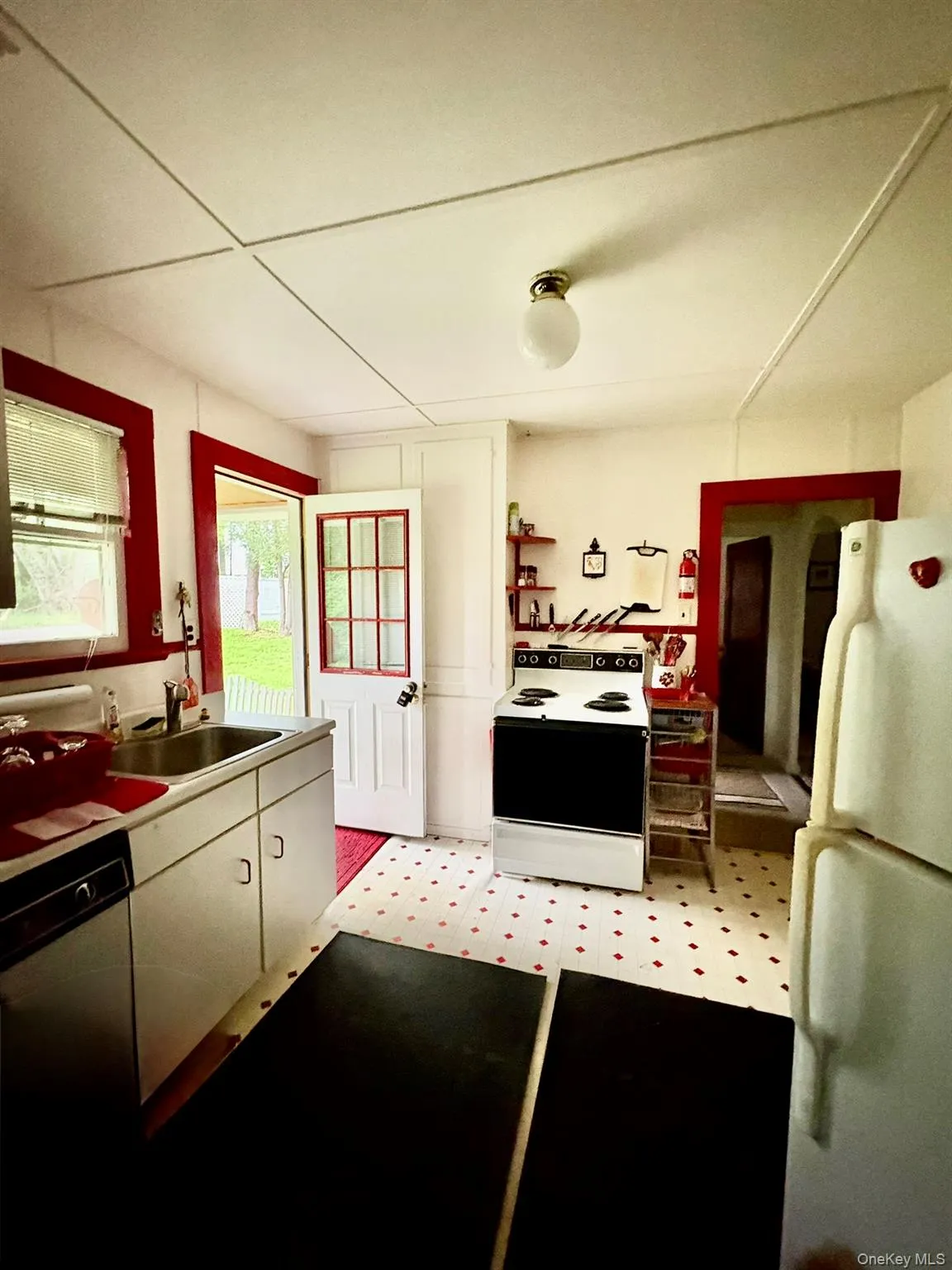 Kitchen with range with electric cooktop, freestanding refrigerator, a sink, and dishwashing machine Kitchen with range with electric cooktop, freestanding refrigerator, a sink, and dishwashing machine