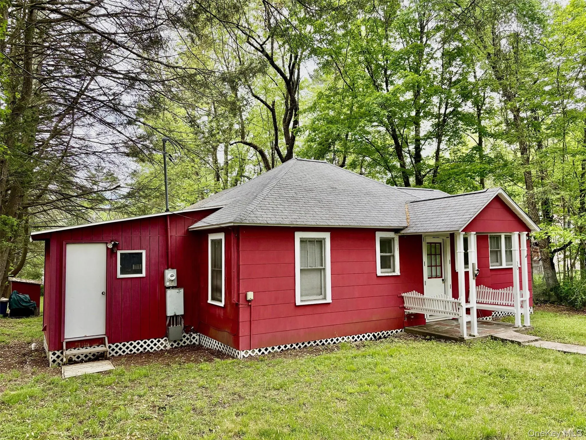 Single story home with a shingled roof and a front yard Single story home with a shingled roof and a front yard