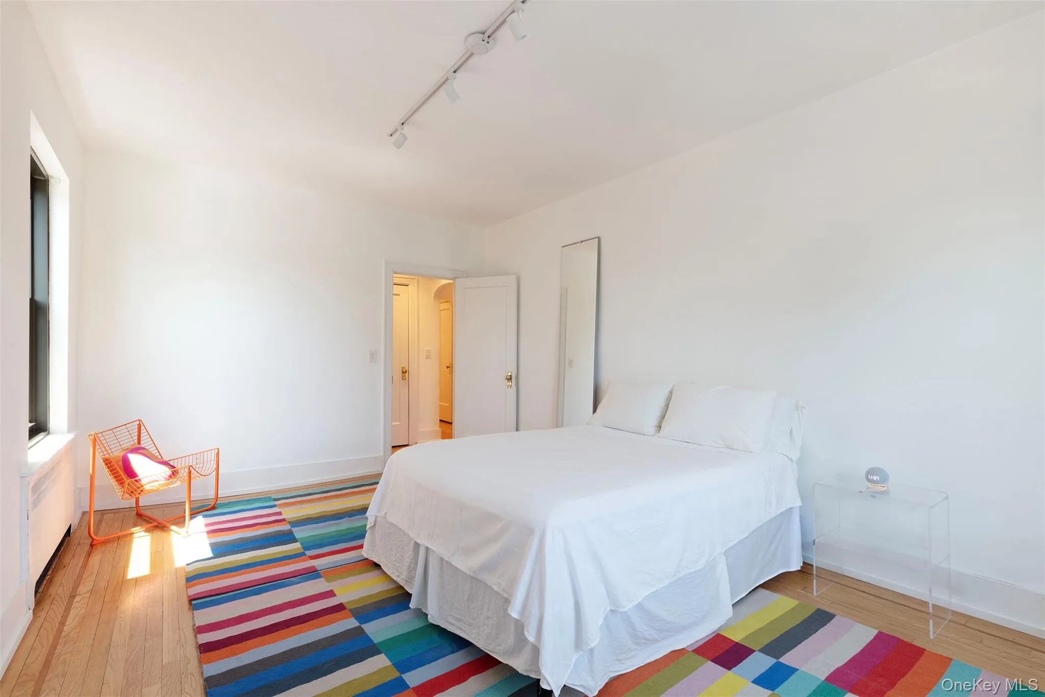 Bedroom with baseboards, wood finished floors, and rail lighting Bedroom with baseboards, wood finished floors, and rail lighting